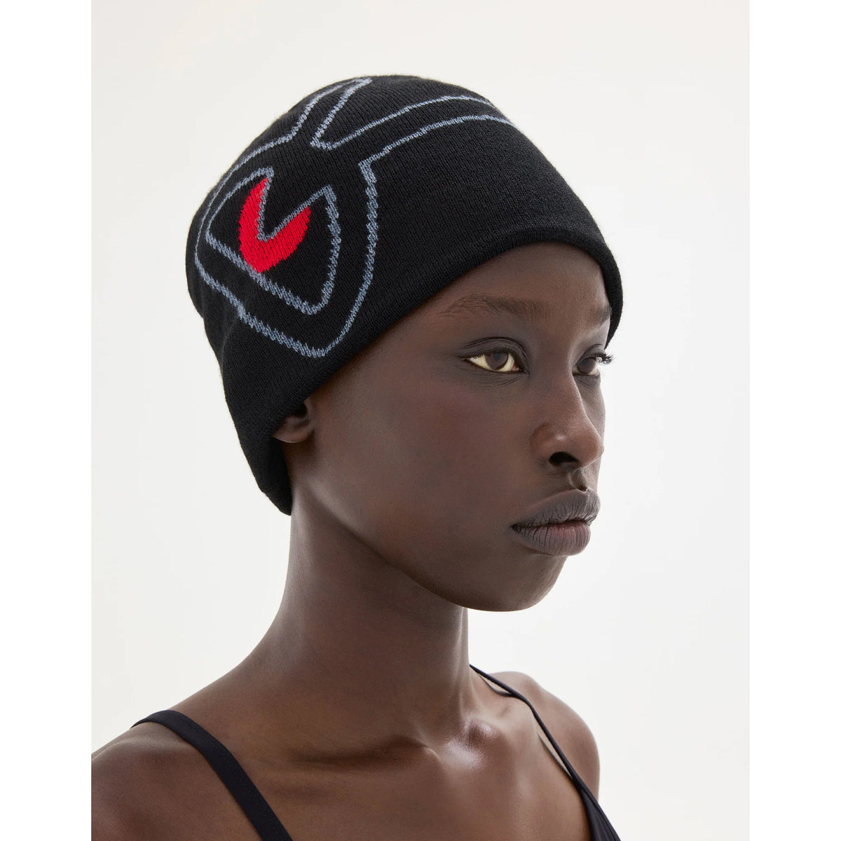 A breathable District Vision Merino Wool Beanie Black / Red in black featuring a red and gray abstract graphic design.