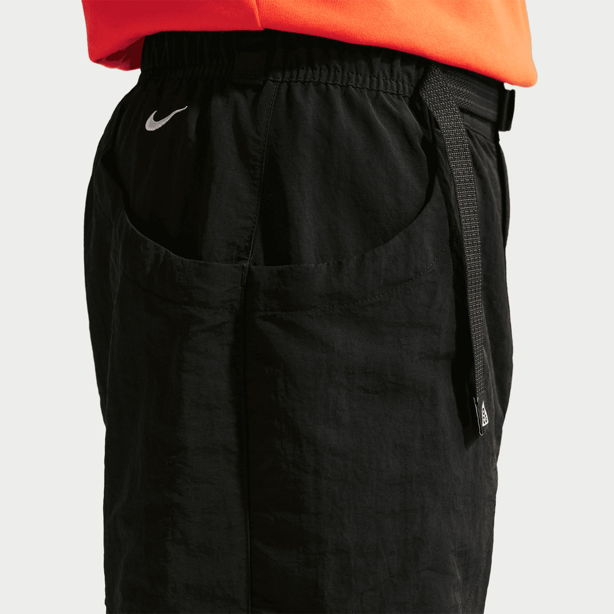 Nike Men's ACG Dolomiti Trousers Black Summit White side close-up showing water-repellent nylon fabric construction and loose fit design