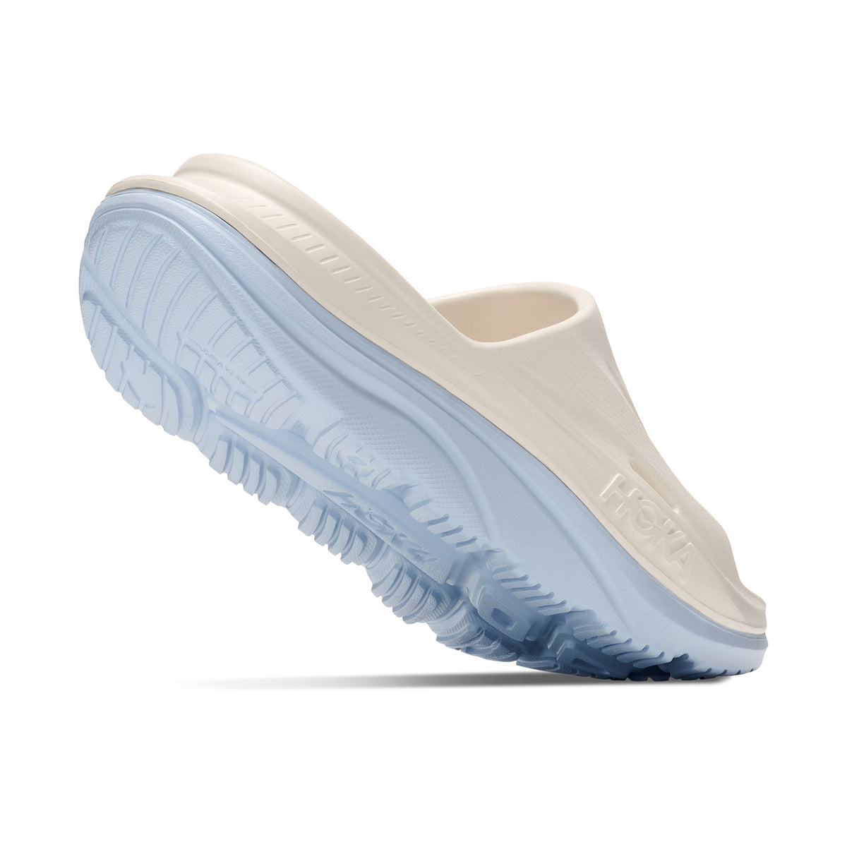 HOKA Ora Recovery Slide 3 Alabaster Ambient Blue angled side and heel view showing dual-density sugarcane EVA midsole with early stage MetaRocker and ventilated channels for foot-cradling post-run recovery comfort