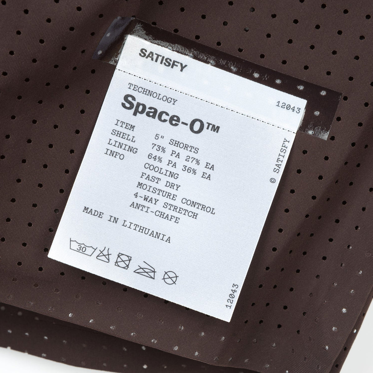Satisfy Space-O™ 5 Inch Distance Shorts in Deep Mahogany — closeup showing fully detachable exterior care label on Space-O™ perforated micro jersey fabric