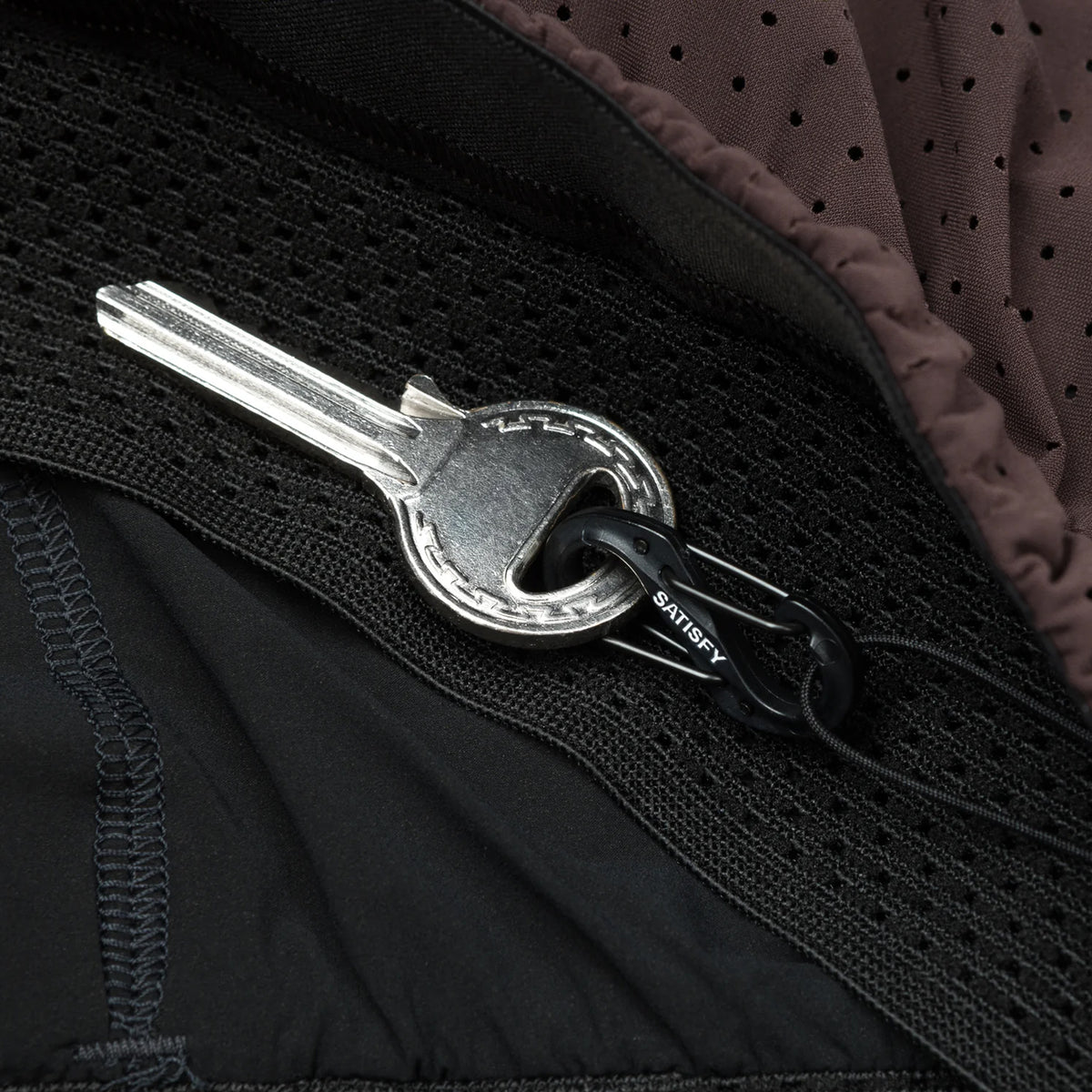 Satisfy Space-O™ 5 Inch Distance Shorts in Deep Mahogany — closeup showing mini S-Carabiner integrated into the double waistband for securing essentials on the run