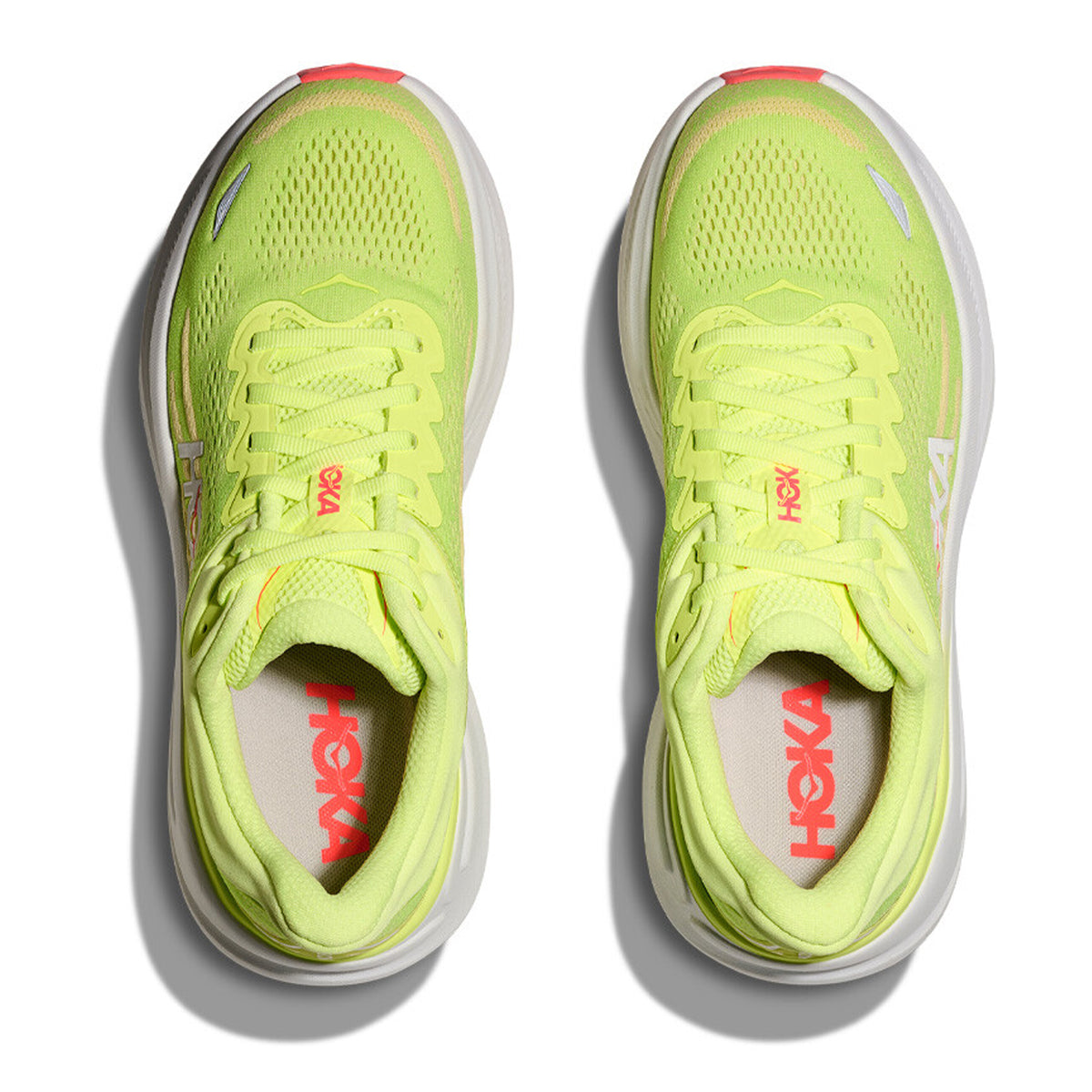 Top view of a pair of Hoka Women’s Bondi 9 Running Shoes in Neon Yuzu / Sunlight with white soles and pink Hoka logos on the tongue and insole, placed side by side on a white background, designed for all-day comfort.