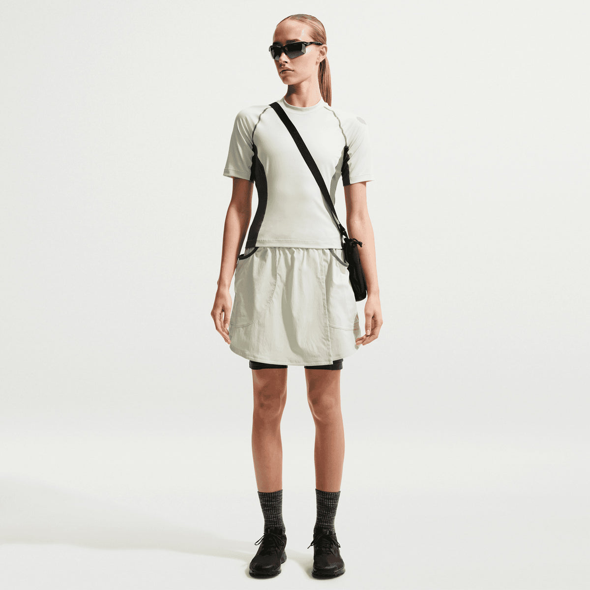 Women's Nike ACG Five Towers Skort Sea Glass Spruce Fog Summit White front full body view on female runner showing convertible skort design with buttons for switching between skirt, shorts or skort configuration