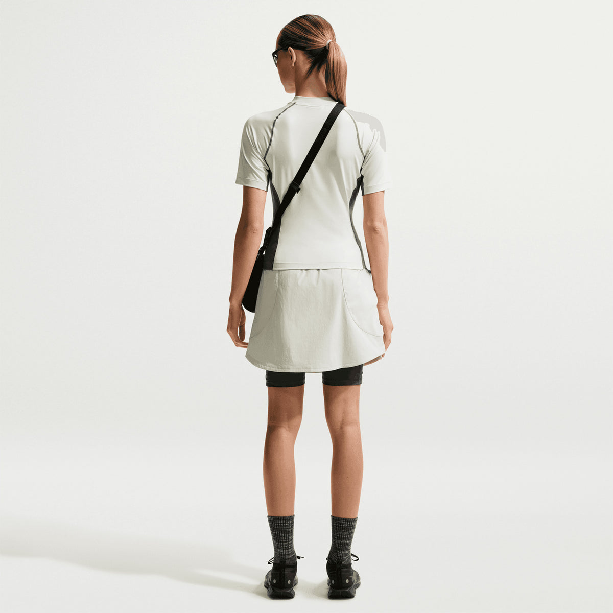 Women's Nike ACG Five Towers Skort Sea Glass Spruce Fog Summit White back full body view on female runner showing Dolomite mountain-inspired design with sweat-wicking technology and storage pockets