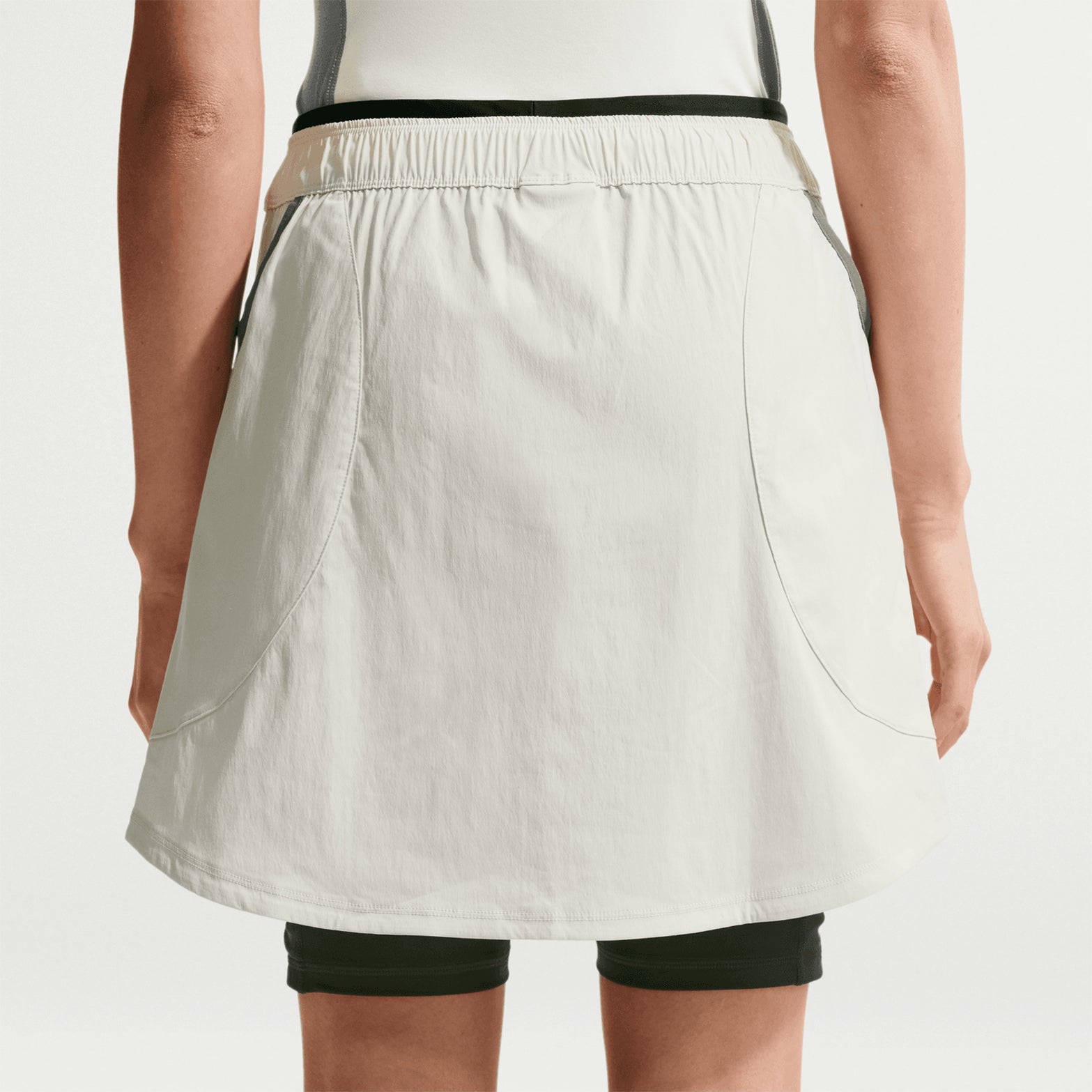Women's Nike ACG Five Towers Skort Sea Glass Spruce Fog Summit White back view on female runner showing trail construction with drop-in pockets and UVA UVB sun protection