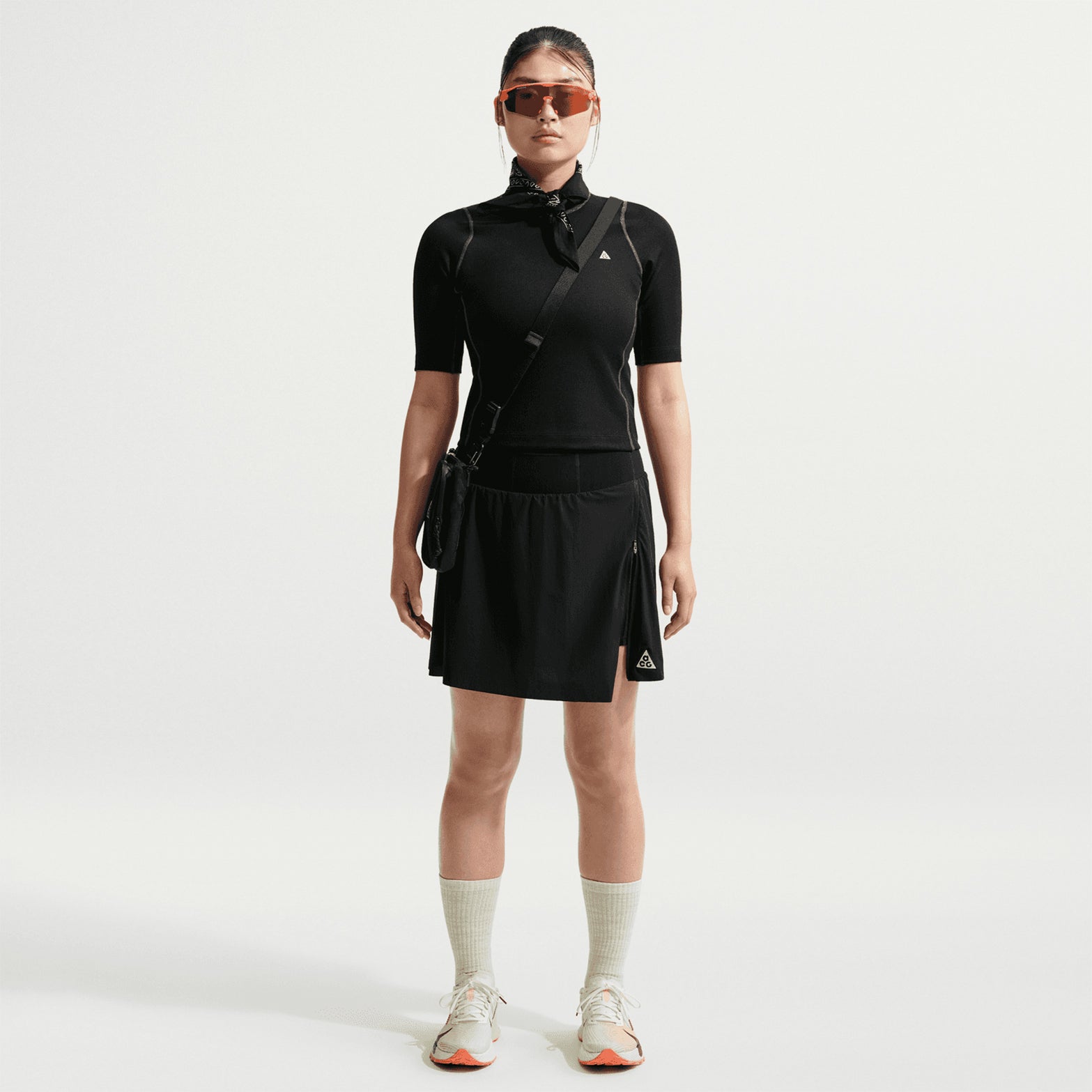 Women's Nike ACG High Stakes Skort Black Black Summit White front full body view on female trail runner showing stretch-woven outer with built-in knit shorts, UV protection and zippered design for hiking and trail activities