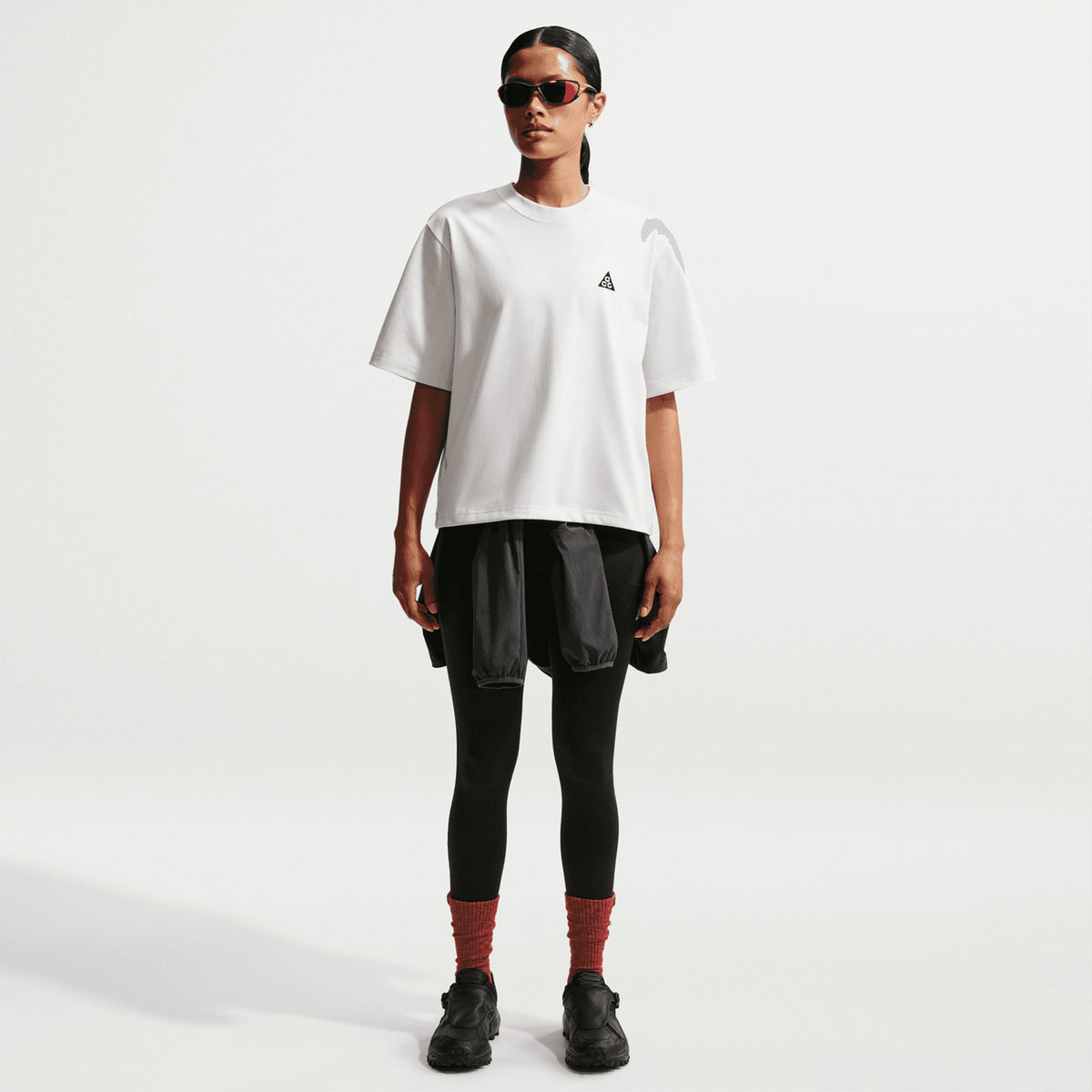 Nike ACG Tee women's in Summit White / Black — back view worn on model showing summit white loose-fit knit construction with black accent detailing and relaxed roomy fit