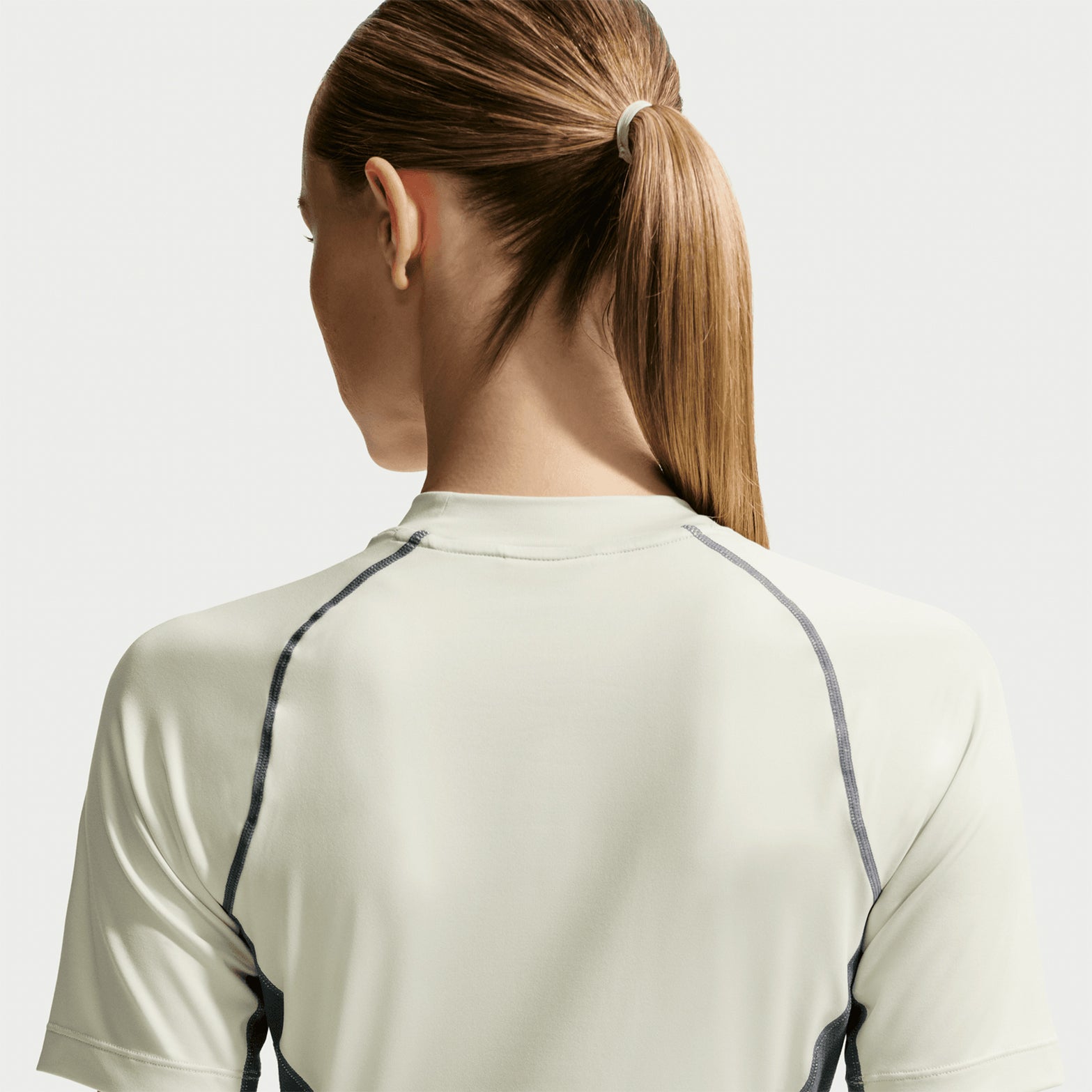 Women's Nike ACG Wildsee Base Layer Tee Sea Glass Mineral Slate Summit White back view showing sweat-wicking construction with ACG nesting system design for layering or solo wear