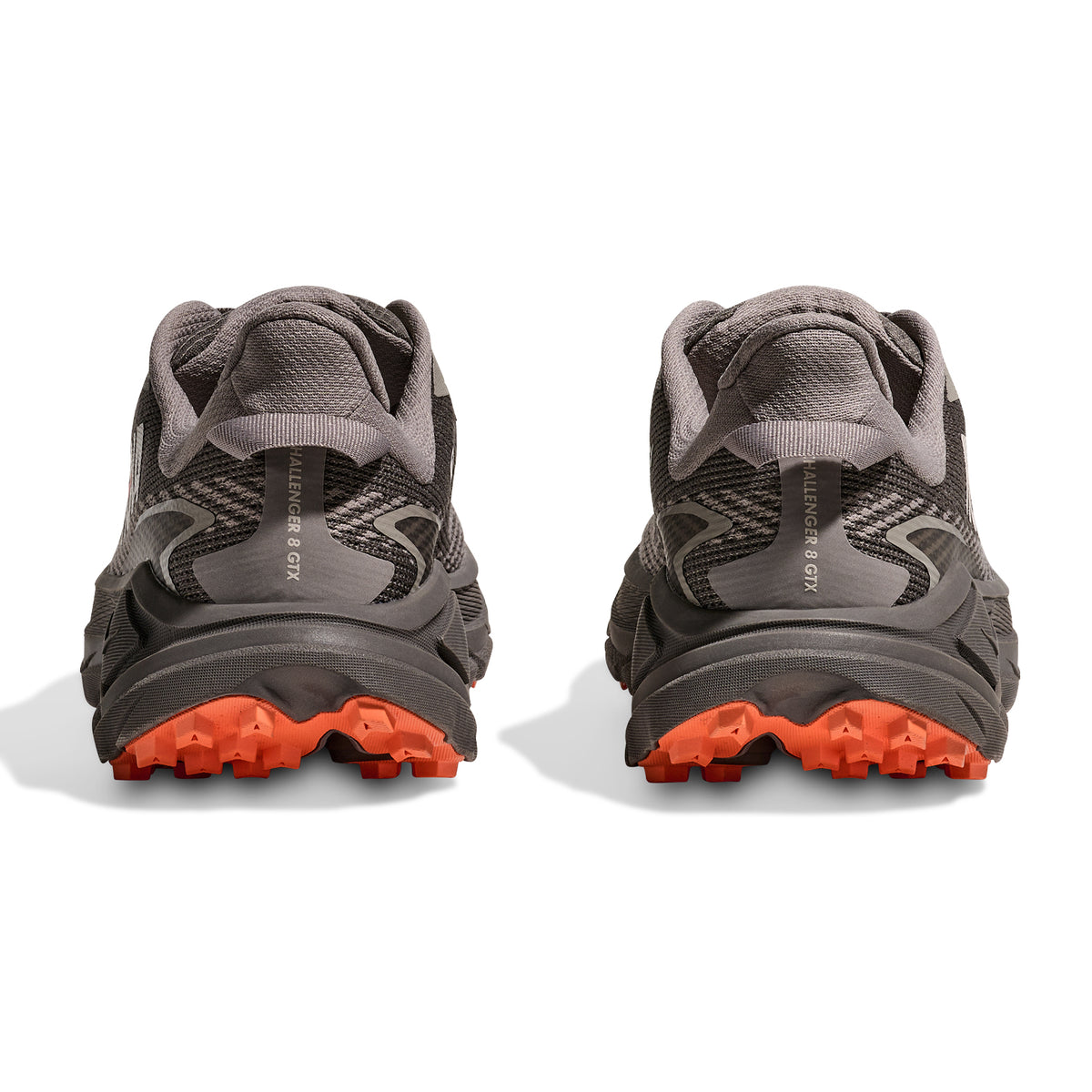 A pair of Hoka Women’s Challenger 8 GORE-TEX Trail Running Shoes in Cement / Gravel with orange soles, displayed from the back against a white background.