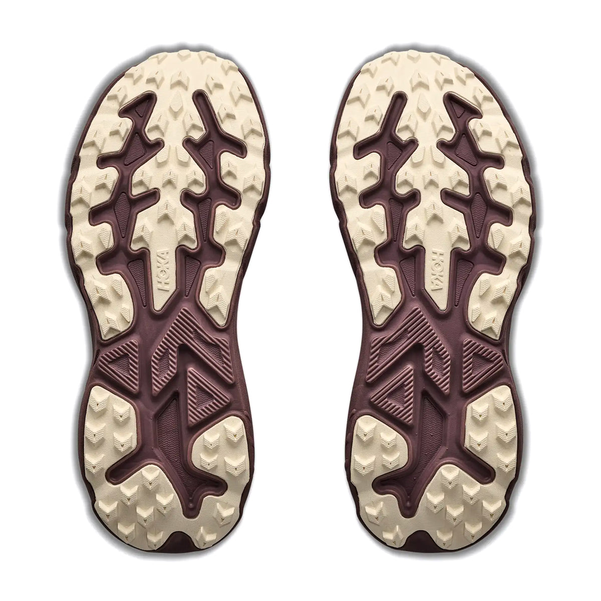 The outsoles of two Women’s Challenger 8 GORE-TEX Trail Running Shoes Smokey Quartz / Alabaster, featuring deep, multi-directional beige lugs on a dark purple base.