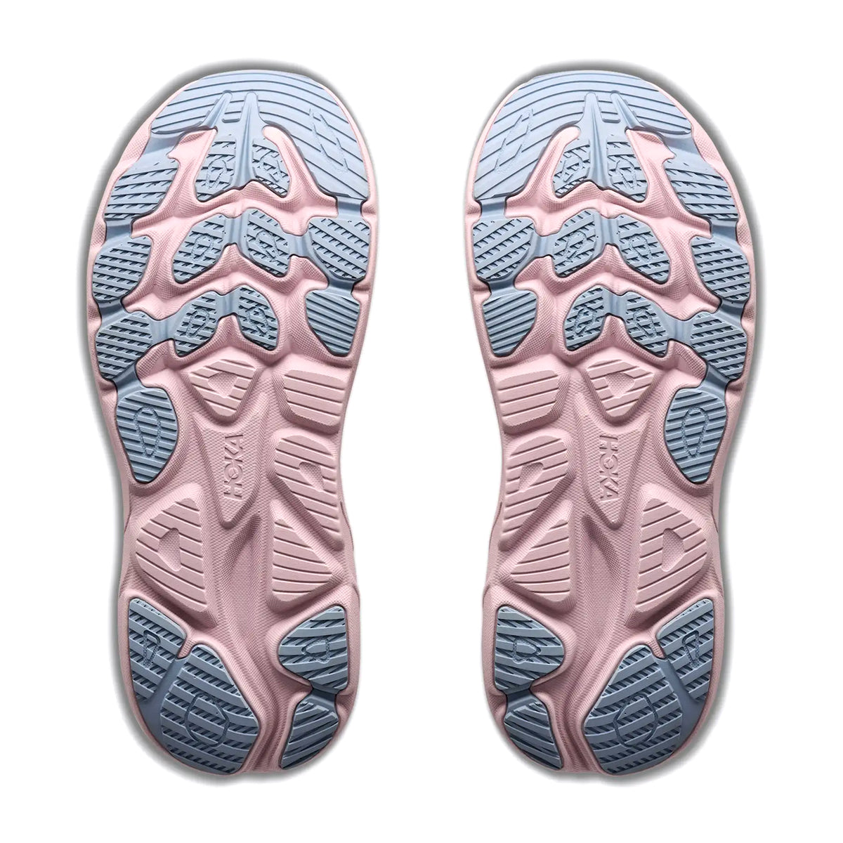 Two sneaker soles from the Hoka Women’s Clifton 11 Glimmers GORE-TEX Running Shoes in Alabaster / Pink Opal are shown side by side on a white background. The soles have a pink base with blue rubber tread patterns, featuring a geometric grip design and EVA cushioning for enhanced comfort, with the Hoka brand name visible on both.