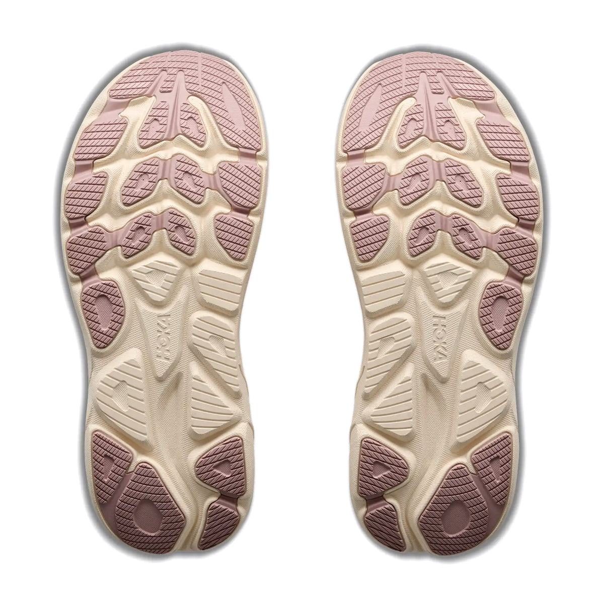 A pair of beige outsoles with pink rubber treads, featuring textured patterns and geometric shapes for grip, is shown from the bottom on a white background. Crafted with compression-moulded foam inspired by Hoka running shoes, these soles offer enhanced comfort and support—specifically designed for the Women’s Clifton 11 Glimmers Running Shoes in Pink Opal / Quartzite by Hoka.