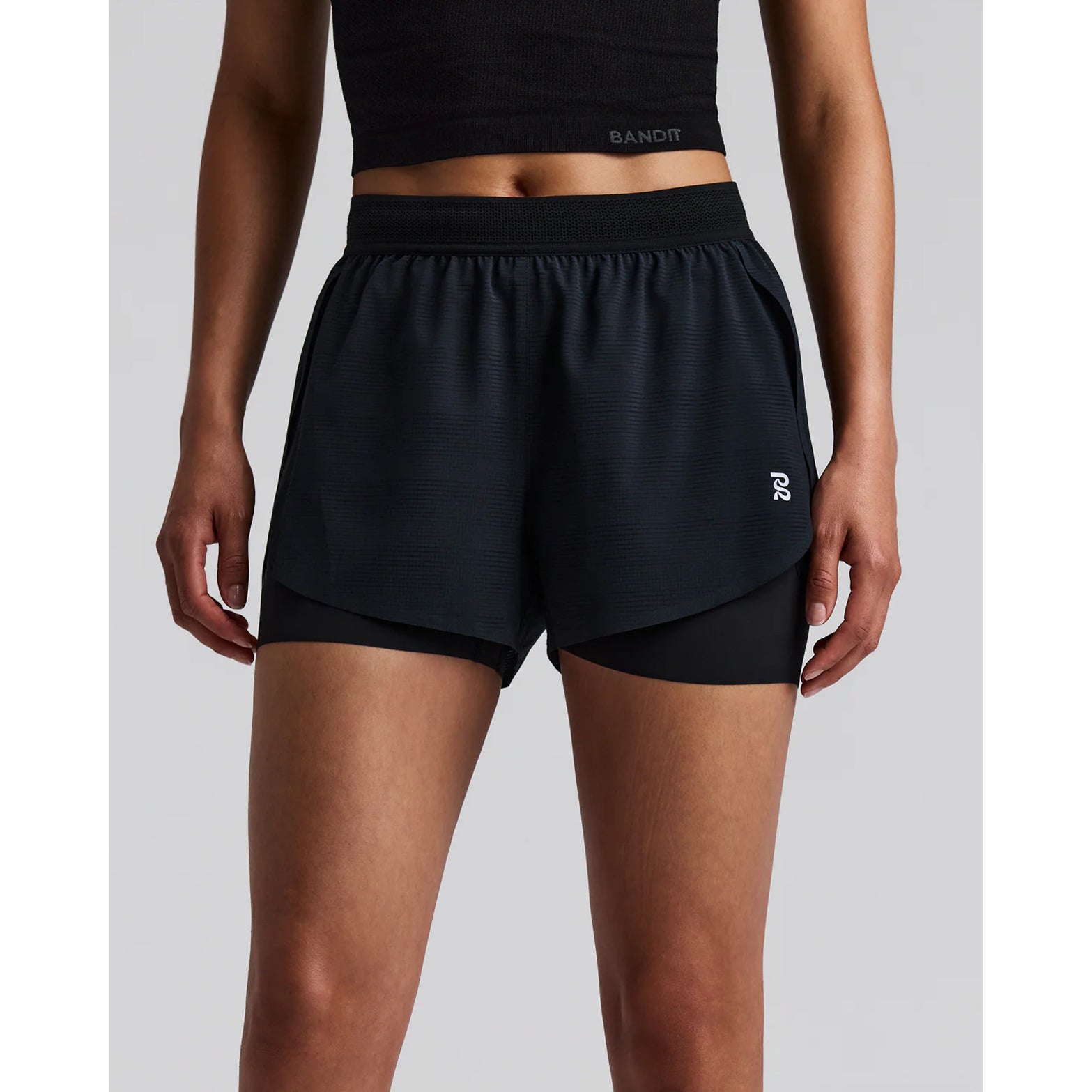 Women's Bandit CoolGrid 2-in-1 Run Short Black front view on female runner showing CoolGrid breathable outer with mesh waistband and waterproof leg phone pockets