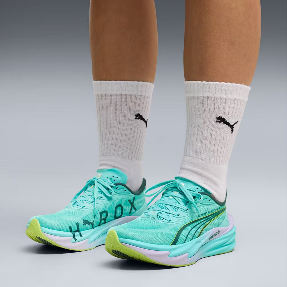 Women's Puma Deviate NITRO 4 HYROX Running Shoes Intense Mint Light Lavender side view on female athlete showing NITROFOAM cushioning with carbon PWRPLATE for propulsive speed during HYROX running intervals and fitness stations