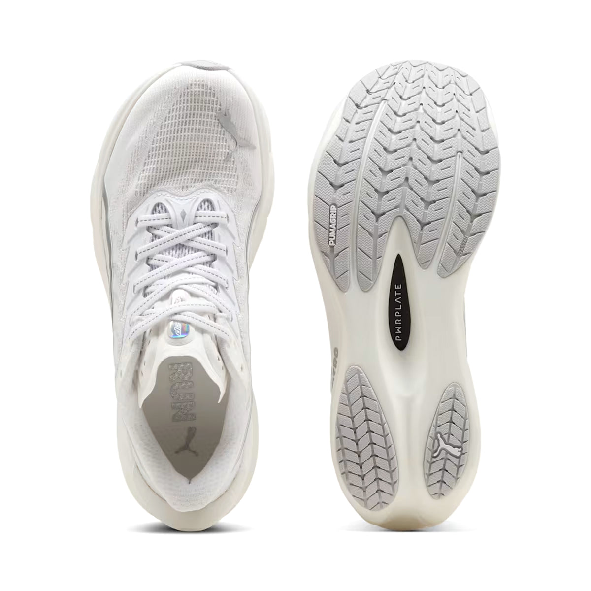 Two white athletic shoes are shown: the left displays the top view with laces and mesh, while the right highlights the sole with a textured tread and PARA PLATE printed in the center. The Women’s Deviate NITRO 4 Running Shoes by Puma, shown here in Puma White / Feather Grey, draw inspiration from innovations like Puma’s carbon racing shoes to deliver lightweight performance and advanced materials for optimal speed and comfort.