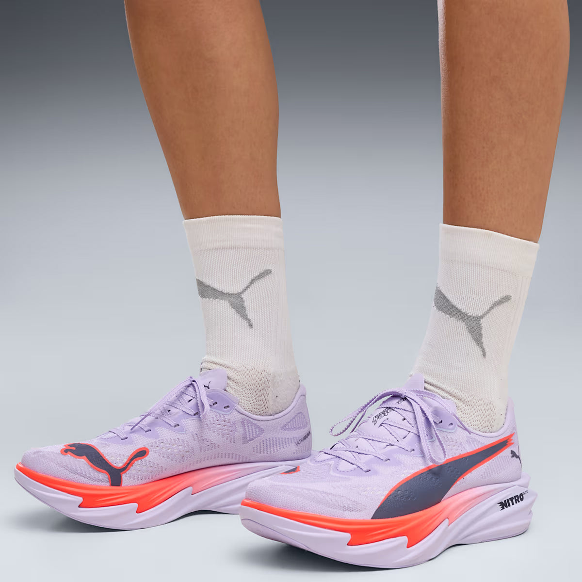 Women's Puma Deviate NITRO Elite 4 Running Shoes Light Lavender Ultra Red Inky Depths side view on female runner showing NITROFOAM Elite foam with carbon fibre PWRPLATE for competitive race day speed and performance