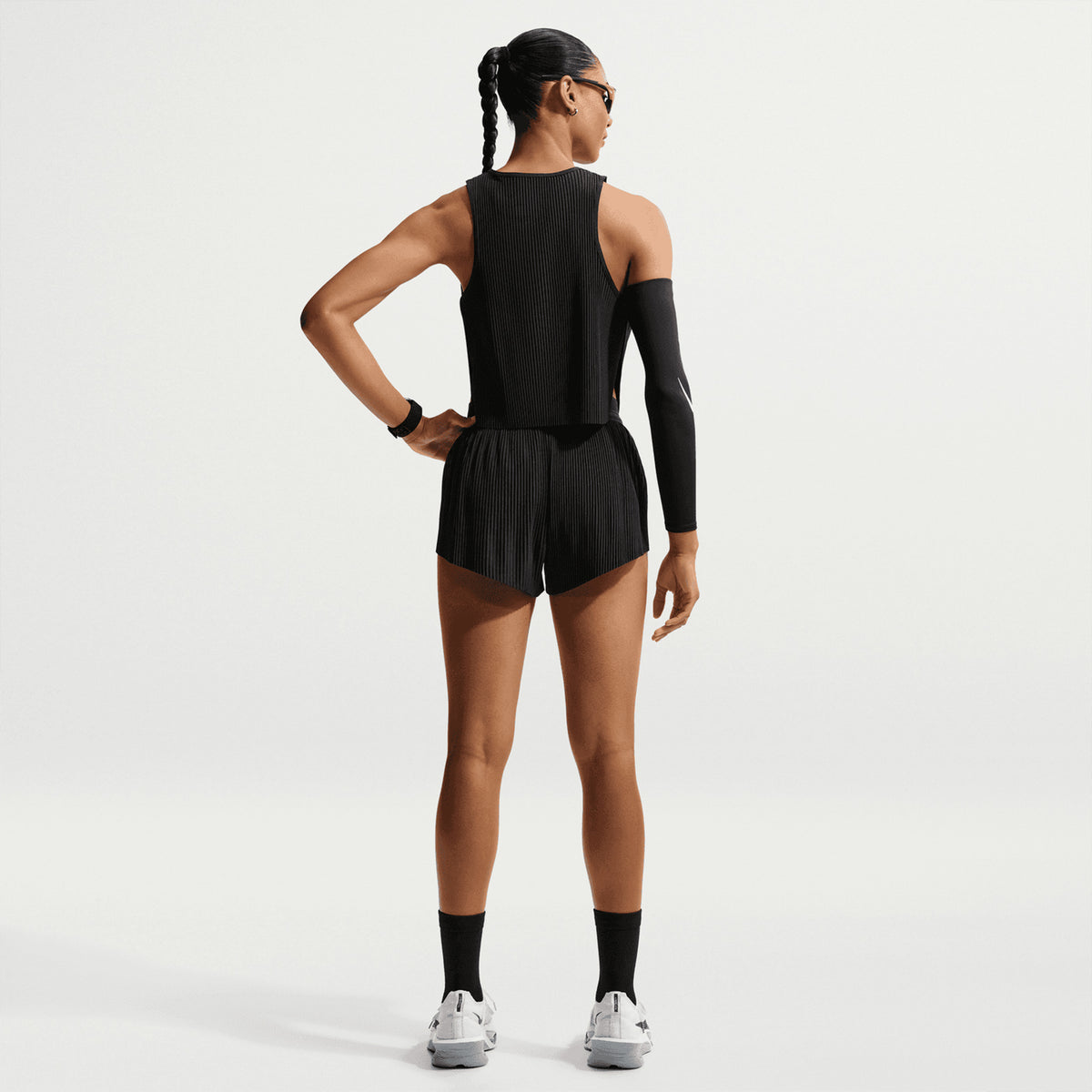 Women's Nike Dri-FIT Aeroswift ADV Cropped Running Tank Black White back full body view on female runner showing breathable cropped design with moisture management for comfortable running
