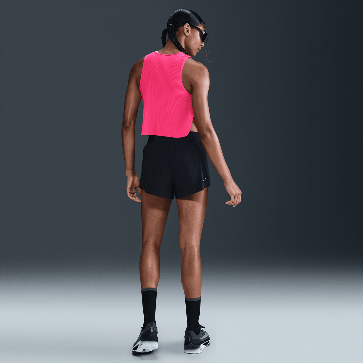 Nike AeroSwift women's Dri-FIT ADV cropped running tank in Hyper Pink / Black — full body back view worn on model showing hyper pink pleated back detail, black accent and lightweight performance-focused construction