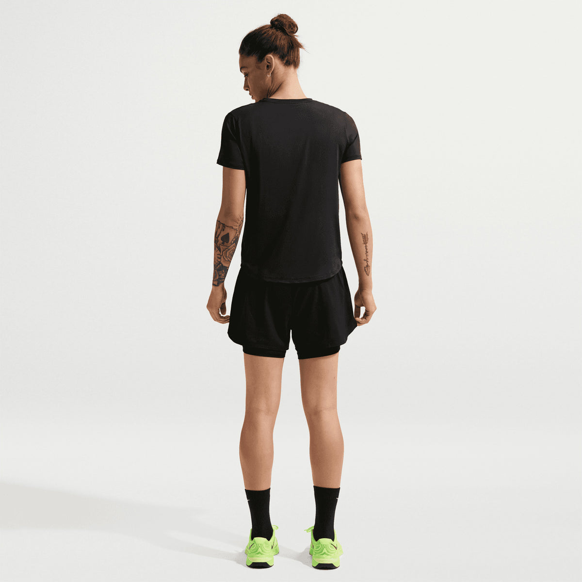 Women's Nike Dri-FIT High-Waisted 3 Inch 2-in-1 Shorts Black White full body back view on female model showing chafe-preventing inner layer and high-rise fit