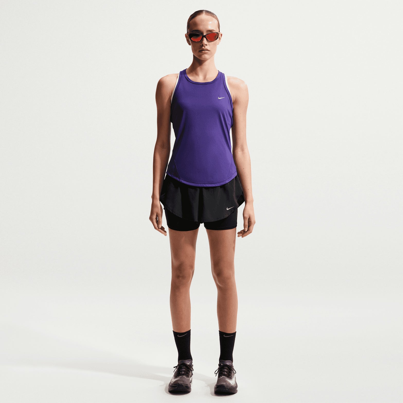 Women's Nike Flow Dri-FIT High-Waisted 2 in 1 Shorts Black front full body view on female runner showing 2-in-1 construction with flowing woven outer, exaggerated tulip hems and high-waisted drawcord waistband for road running