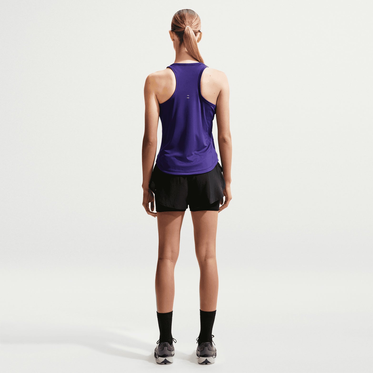 Women's Nike Flow Dri-FIT High-Waisted 2 in 1 Shorts Black back full body view on female runner showing back waistband phone pocket with flowing woven outer and Dri-FIT moisture-wicking for comfortable daily training