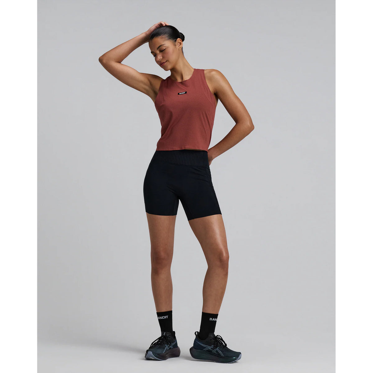 Women's Bandit GeoMesh Race Singlet Mahogany full body front view on female runner showing cropped singlet with bonded chafe-free seams and quick-drying construction