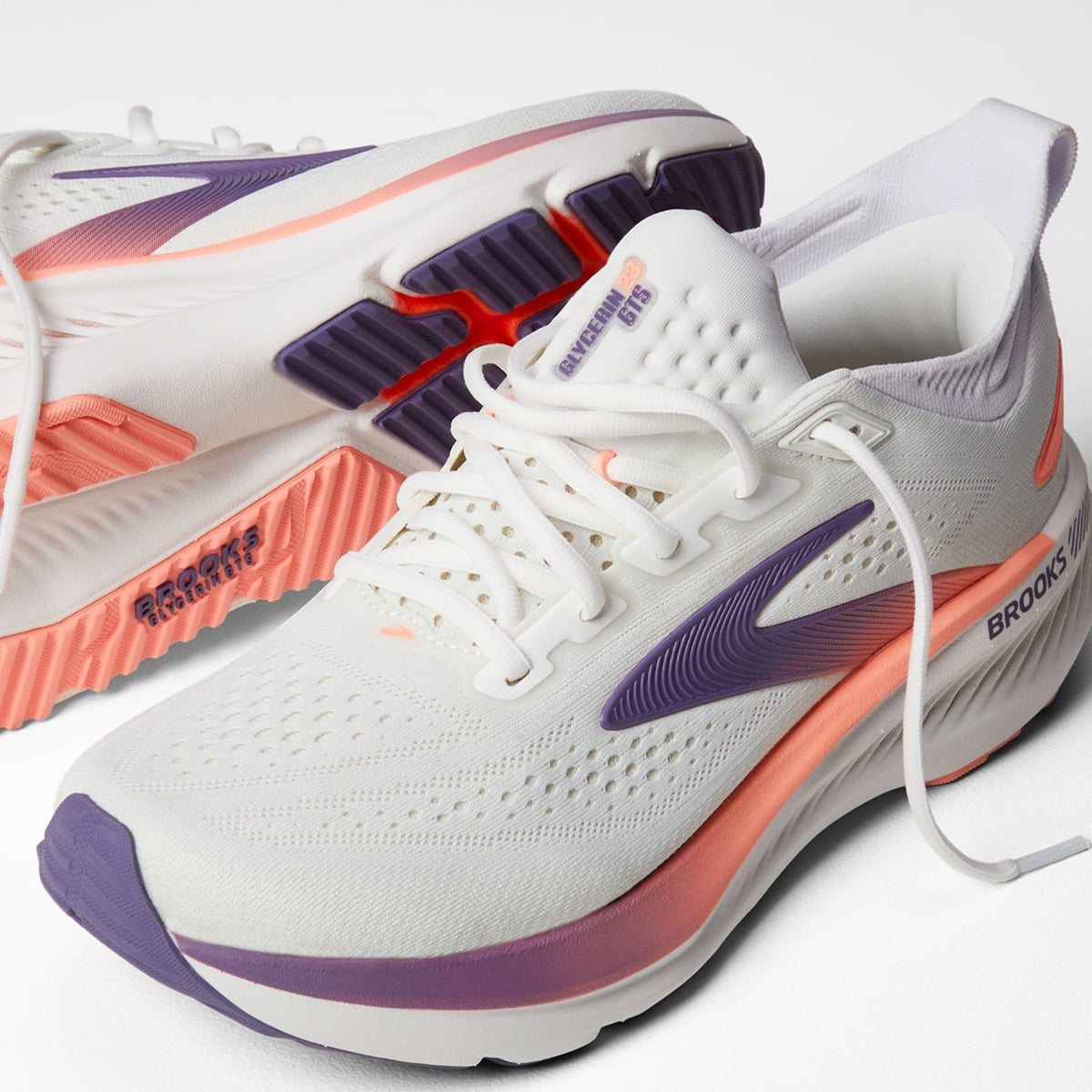 Brooks Glycerin GTS 23 women's running shoe in White / Mulled Grape / Clear — angled side view showing white engineered knit upper, GuideRails support sidewalls and mulled grape DNA TUNED cushioning midsole stack with 8mm offset profile