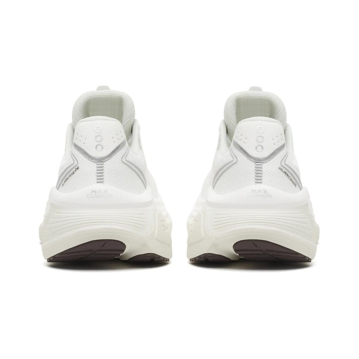 A pair of Women’s Hurricane 26 Running Shoes by Saucony, shown from the back in White / Quartz, feature thick soles and subtle gray accents. These cushioned sneakers are placed side by side on a white background, making them an ideal choice for anyone seeking a reliable daily trainer.