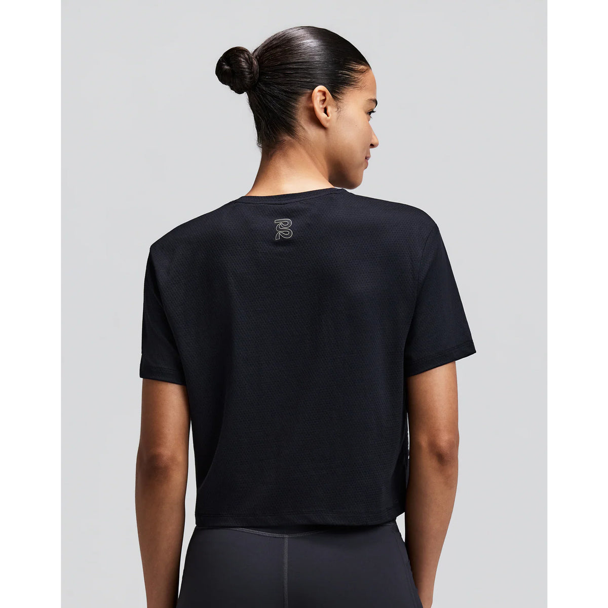 Women's Bandit Micromesh Cropped Run Tee Black back view on female runner showing breathable Micromesh construction with fast-drying sweat-wicking fabric for comfortable running