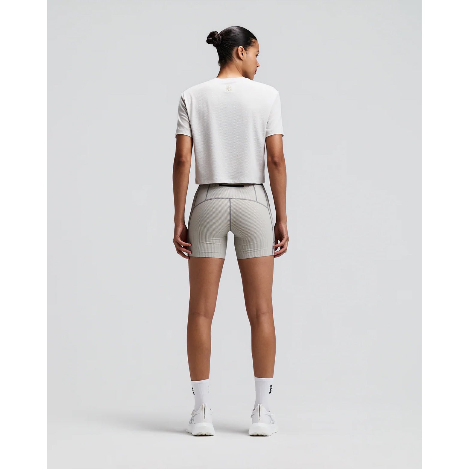 Women's Bandit Micromesh Cropped Run Tee Plaster back full body view on female runner showing relaxed boxy cropped fit with fast-drying Micromesh construction for comfortable running and training