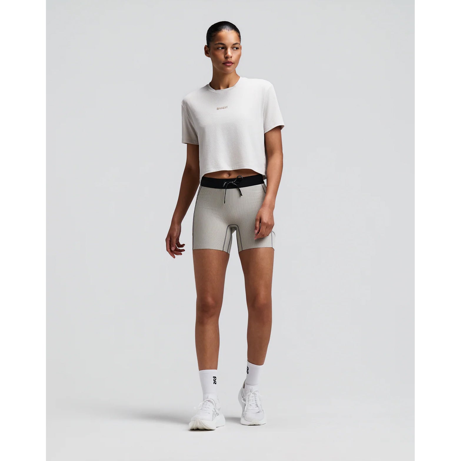 Women's Bandit Micromesh Cropped Run Tee Plaster front full body view on female runner showing relaxed boxy cropped silhouette with crew neckline and breathable Micromesh moisture-wicking for training and everyday running