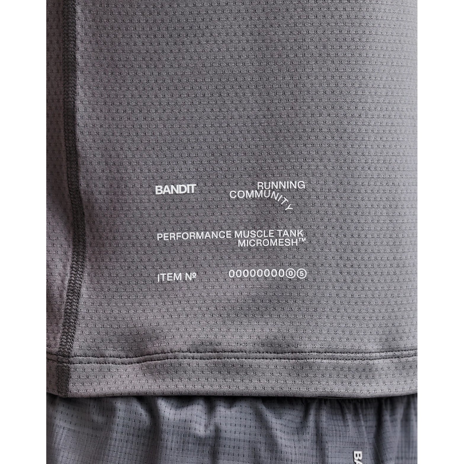 Women's Bandit Micromesh Run Tank Slate close-up of hem showing subtle two-tone Bandit logo with reflective details for low-light visibility during running