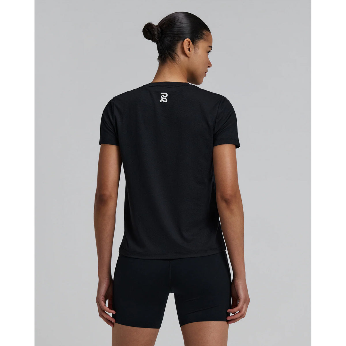 Bandit Micromesh Run Tee women's in Black — back view worn on model showing relaxed fit, Micromesh™ breathable fabric construction and dyed-to-match reflective graphic at centre back