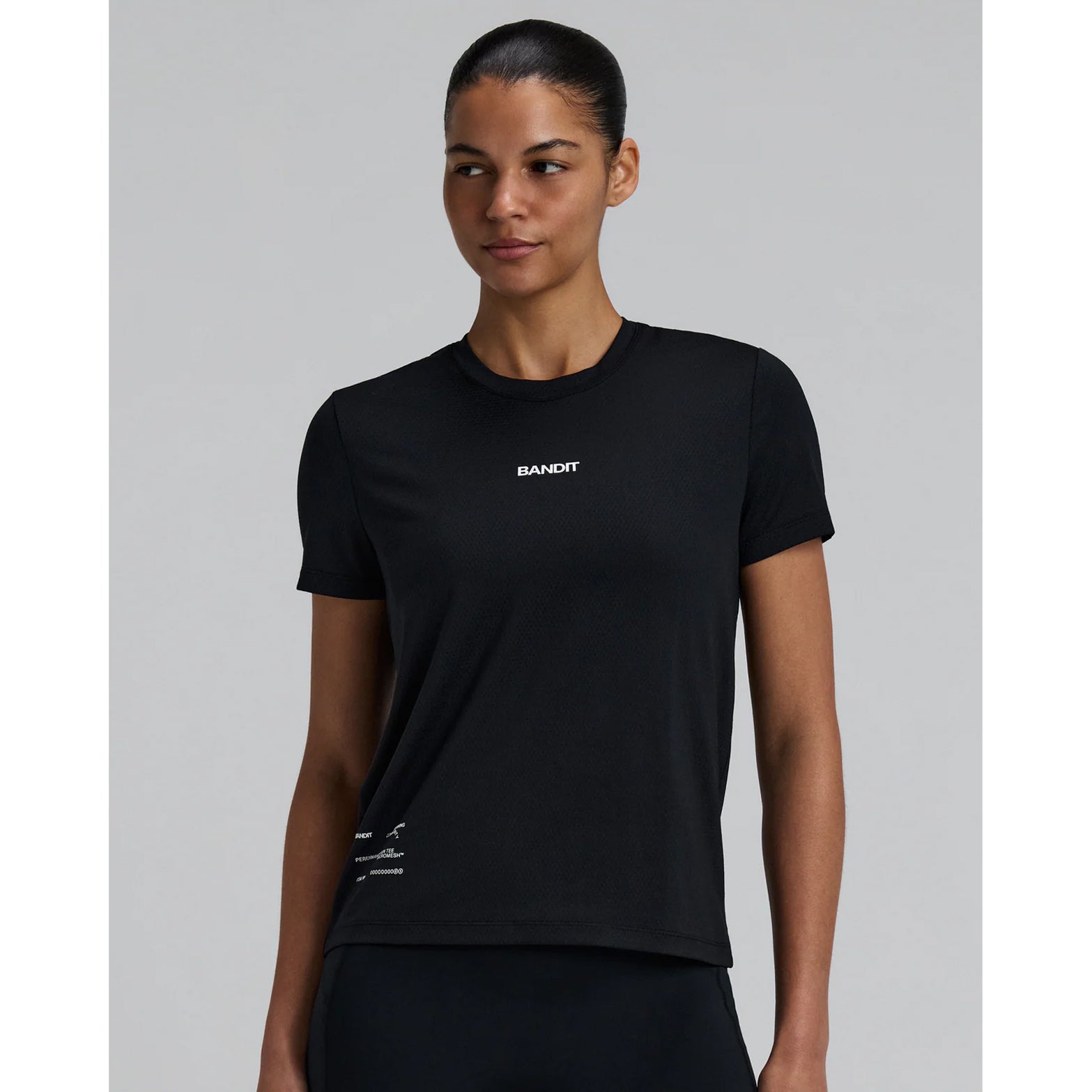Bandit Micromesh Run Tee women's in Black — front view worn on model showing relaxed fit, Micromesh™ fabric drape and dyed-to-match reflective graphic at centre front