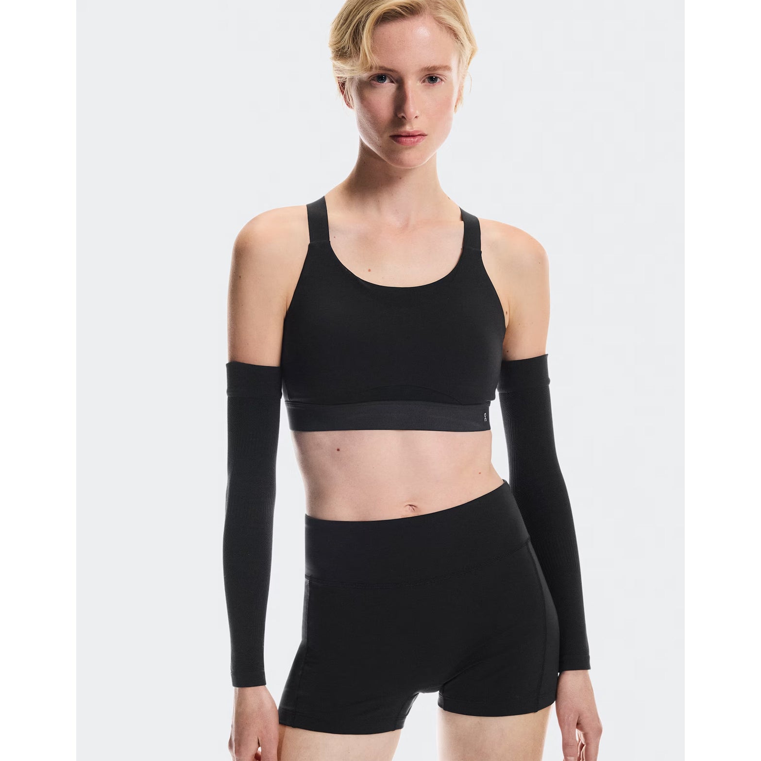 Women's On Performance Bra Black front view on female runner showing pull-on design with smooth four-way stretch material and adjustable straps