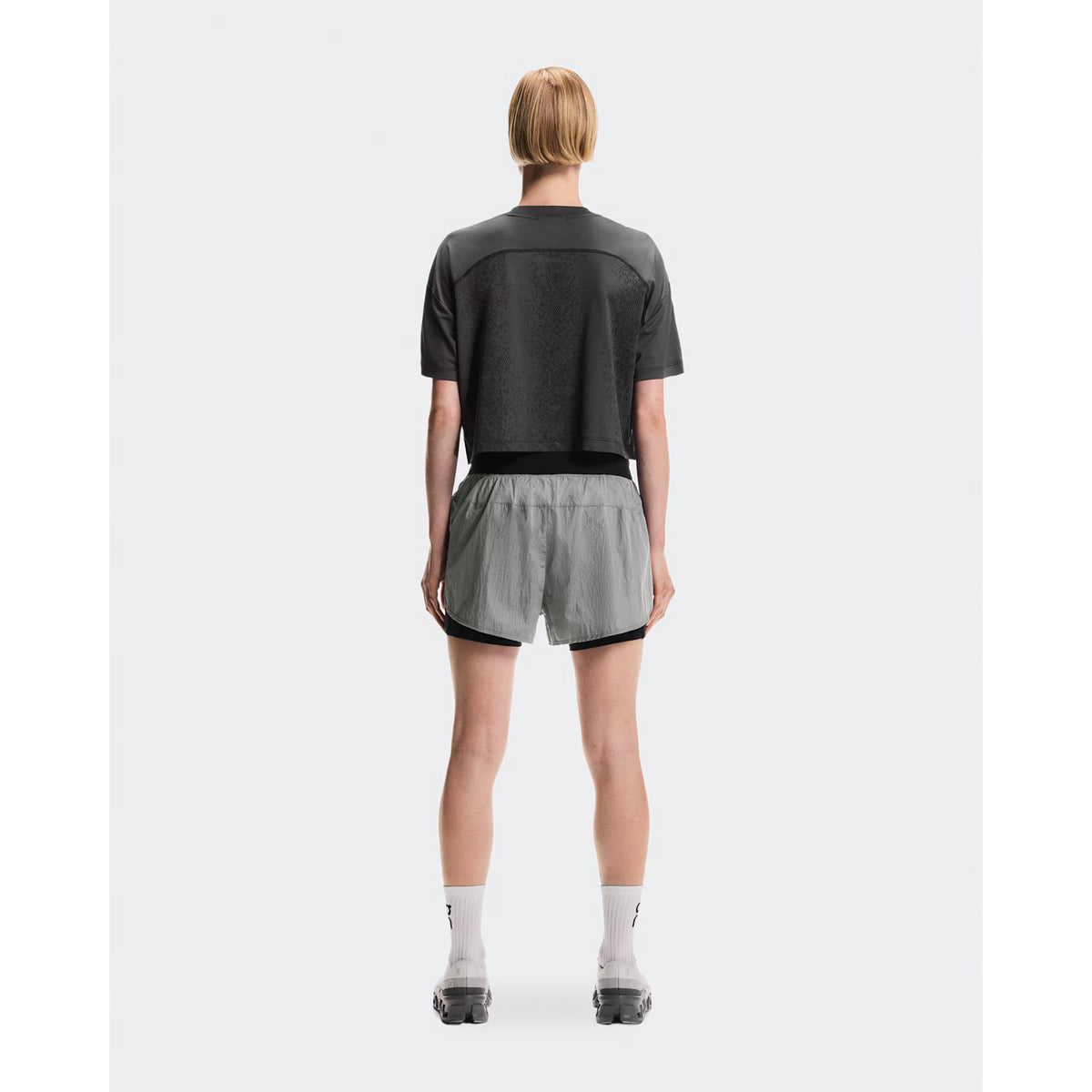 Women's On Performance Volt-T Iron full body back view on female runner showing versatile relaxed cut with quick-dry moisture-wicking performance for everyday activities
