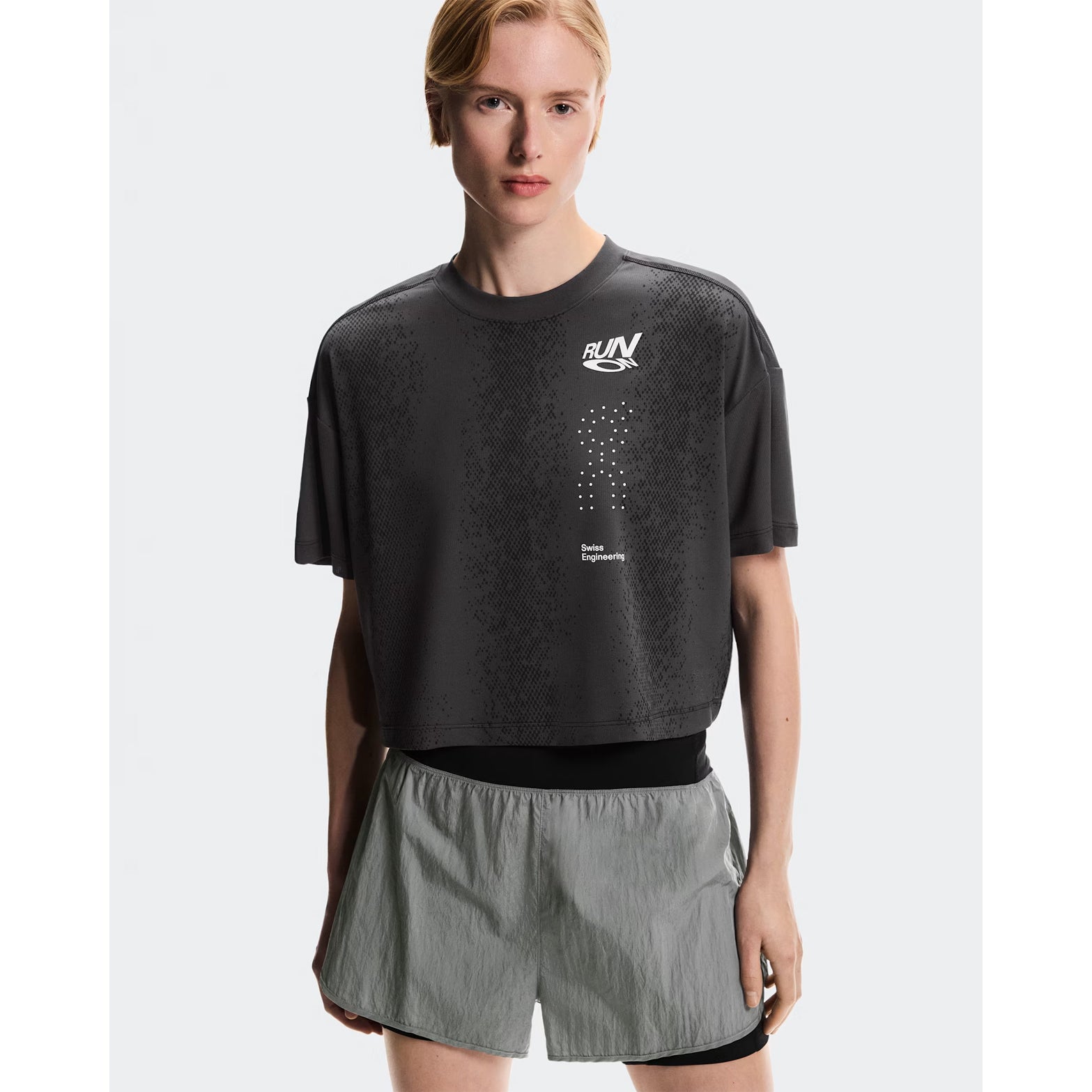 Women's On Performance Volt-T Iron front view on female runner showing lightweight moisture-wicking construction with bold typographic run-culture design