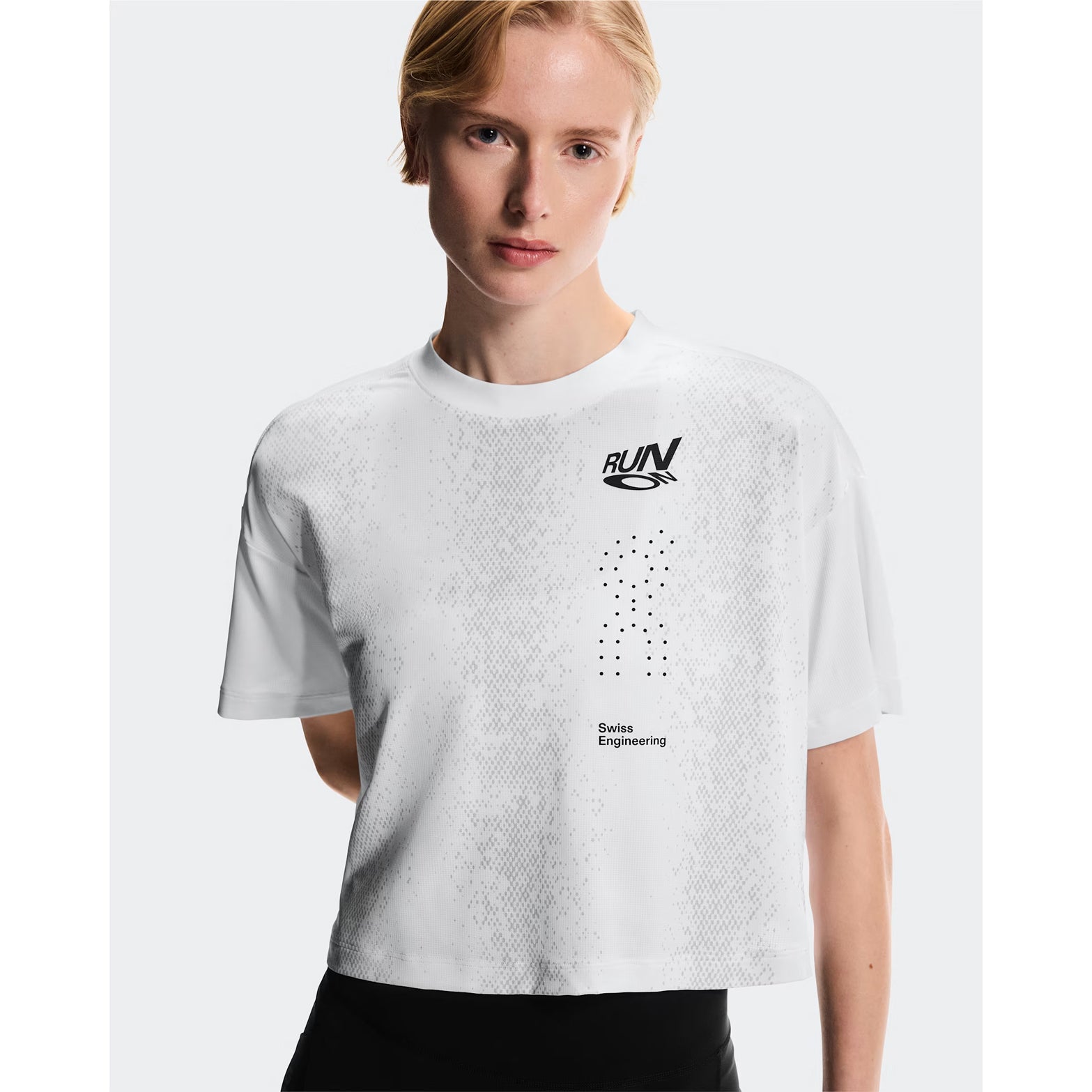 Women's On Performance Volt-T White front view on female runner showing lightweight moisture-wicking construction with bold typographic run-culture design