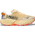 A Women’s Speedgoat 7 Trail Running Shoe by Hoka in Vintage Yellow / Neon Flame, featuring bold black HOKA branding, an orange heel tab, a reflective detail on the heel, and a thick, textured sole with red Vibram Megagrip tread. The shoe is displayed in a side profile view.