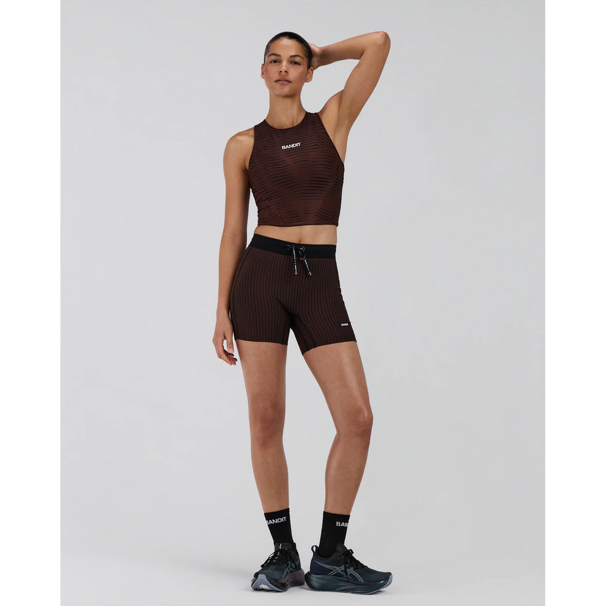 Women's Bandit Stamina Race Crop Organic Stripe Cacao full body front view on female runner showing classic race crop silhouette with built-in bra and moisture-wicking Stamina fabric