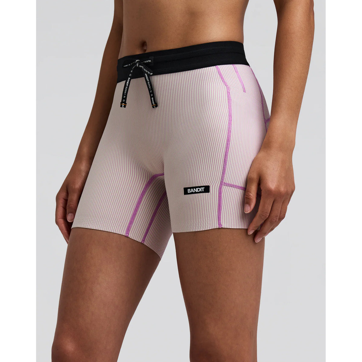 Women's Bandit Striped Cadence 5 Inch Compression Shorts Plaster Orchid side view on female runner showing 5-inch inseam with ultra-compressive Striped Cadence ribbed knit and custom anti-chafe waistband for comfortable race day performance