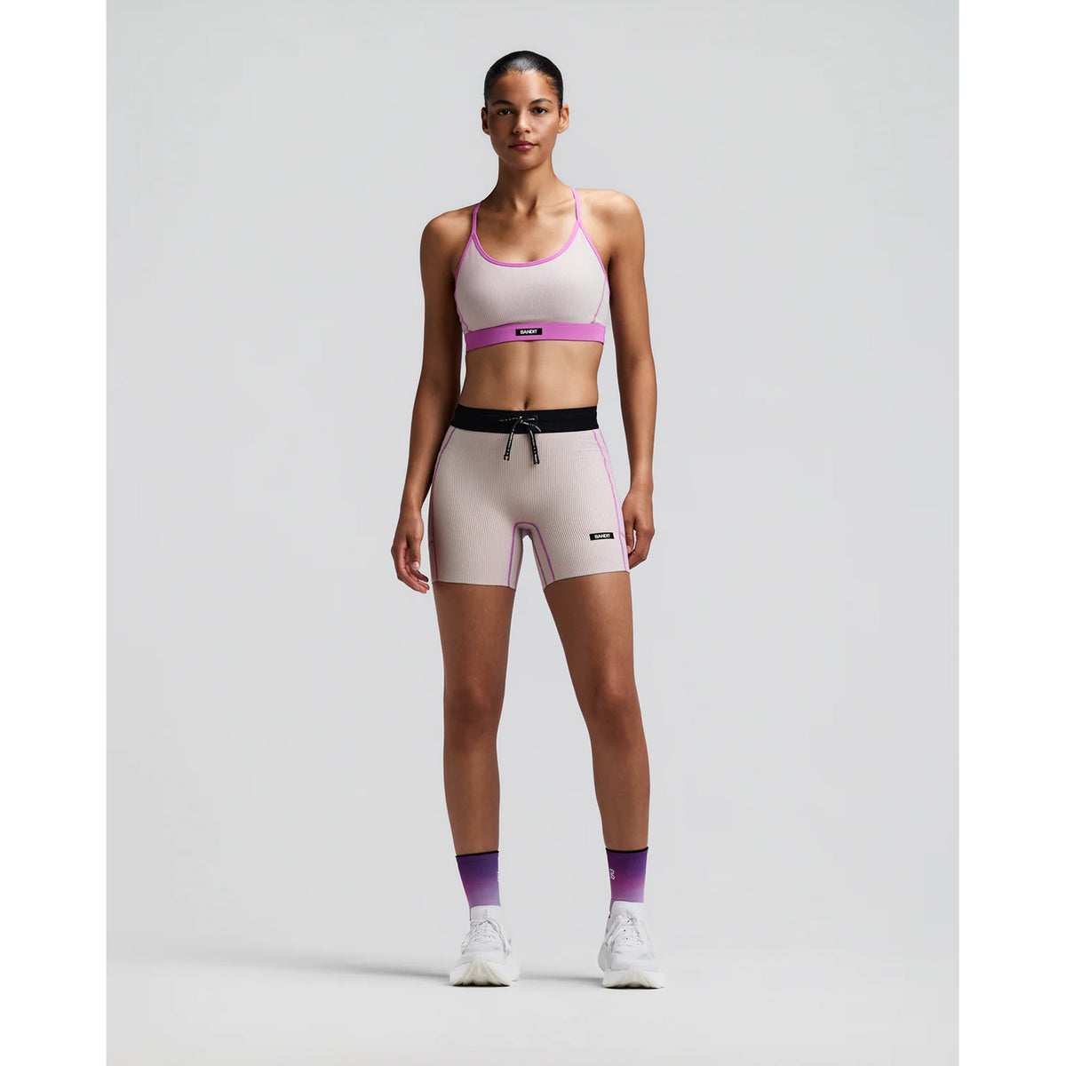 Women's Bandit Striped Cadence 5 Inch Compression Shorts Plaster Orchid front full body view on female runner showing 5-inch inseam with ultra-compressive ribbed knit and five-pocket storage system for racing and marathon training