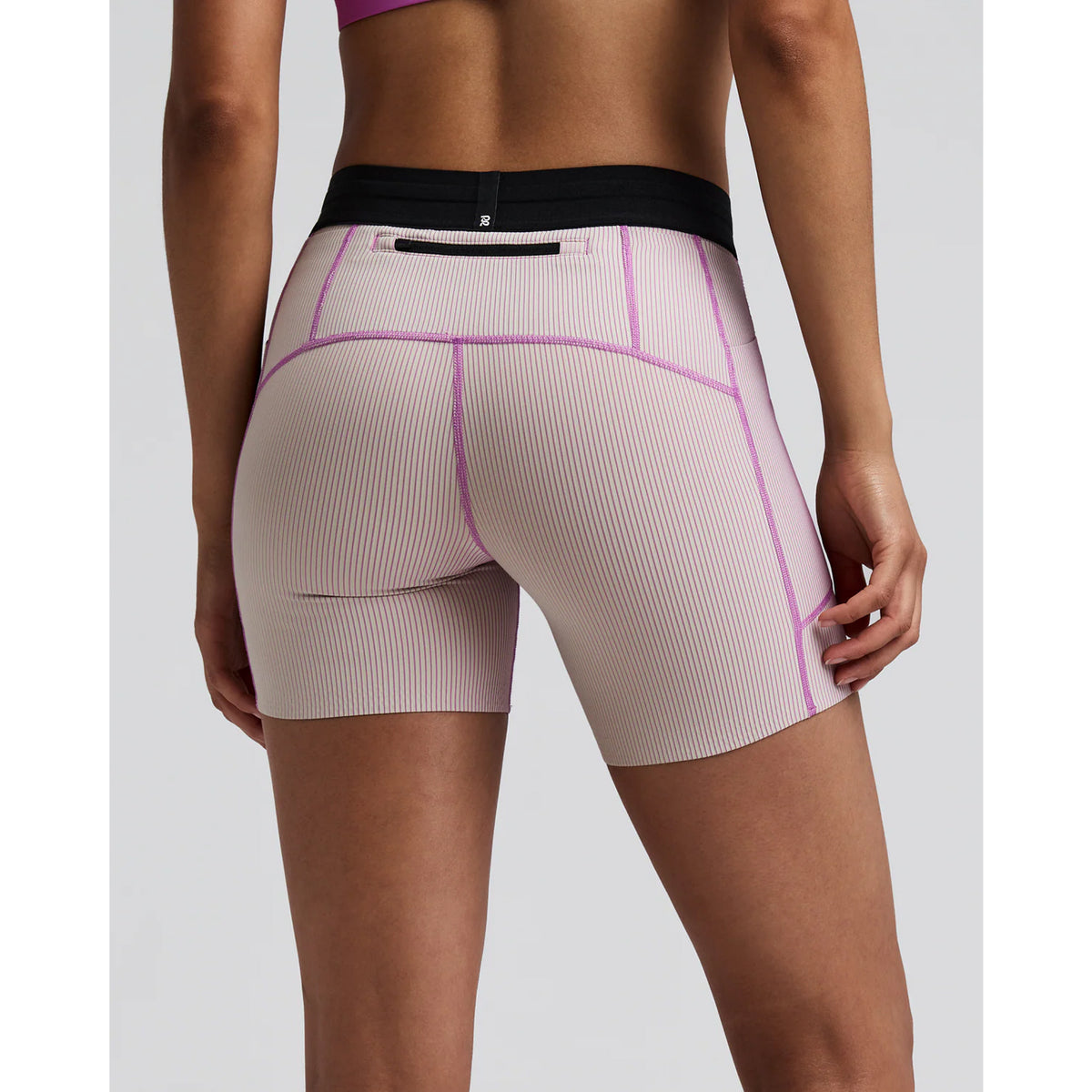 Women's Bandit Striped Cadence 5 Inch Compression Shorts Plaster Orchid back view on female runner showing back zipper pocket with grip tape hems and subtle silicone logo detailing