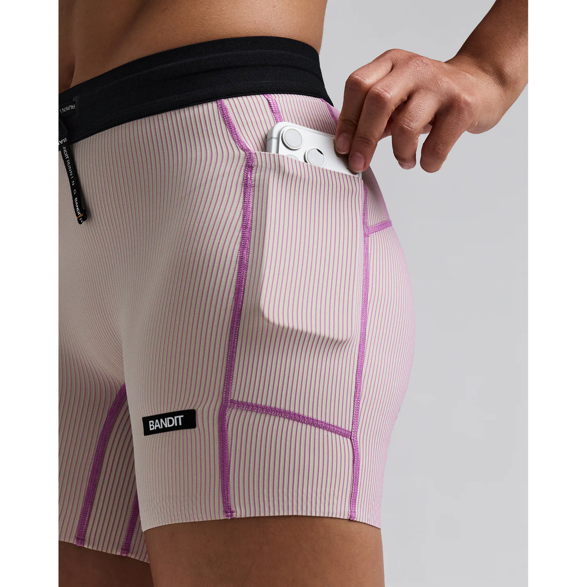 Women's Bandit Striped Cadence 5 Inch Compression Shorts Plaster Orchid close-up of side phone pocket showing waterproof liner for sweat protection with secure hidden storage for race day essentials without bounce