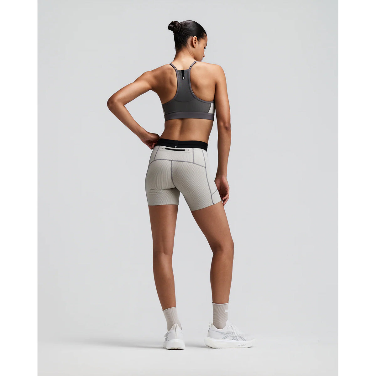 Women's Bandit Striped Cadence 5 Inch Compression Shorts Plaster Slate back full body view on female runner showing grip tape hems with back zipper pocket and ultra-compressive Striped Cadence construction for long-distance running