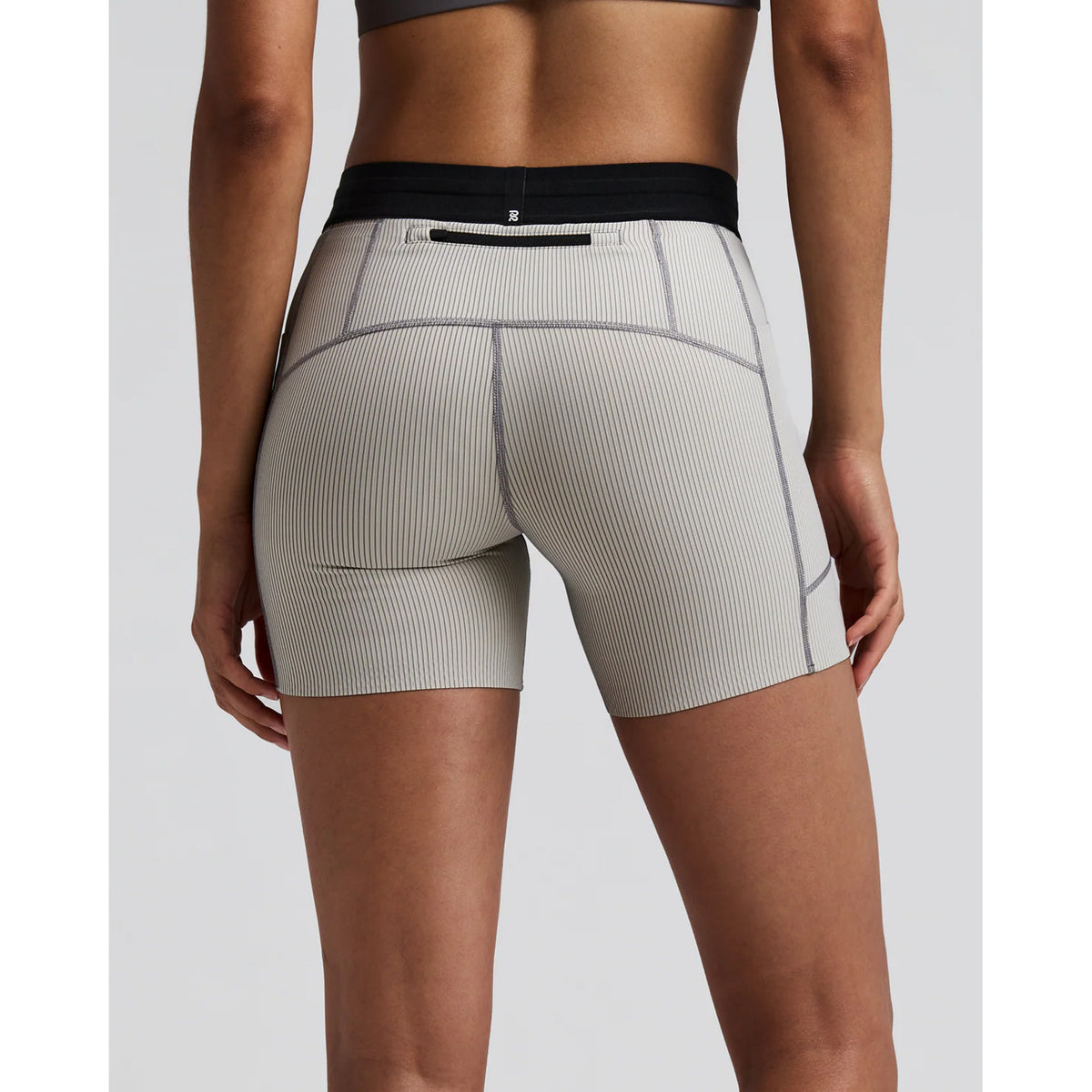 Women's Bandit Striped Cadence 5 Inch Compression Shorts Plaster Slate back view on female runner showing back zipper pocket with grip tape hems and subtle silicone logo detailing