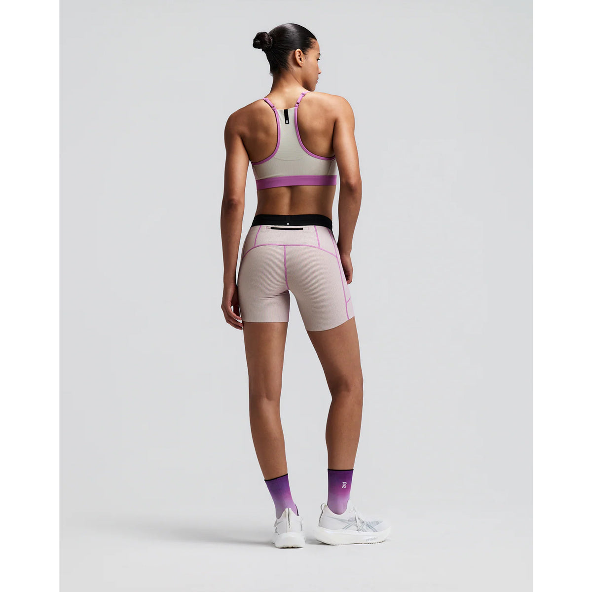 Women's Bandit Striped Cadence Strappy Bra Plaster Orchid back full body view on female runner showing Powermesh back panel with waterproof phone pocket and Vanisher band for comfortable race day performance