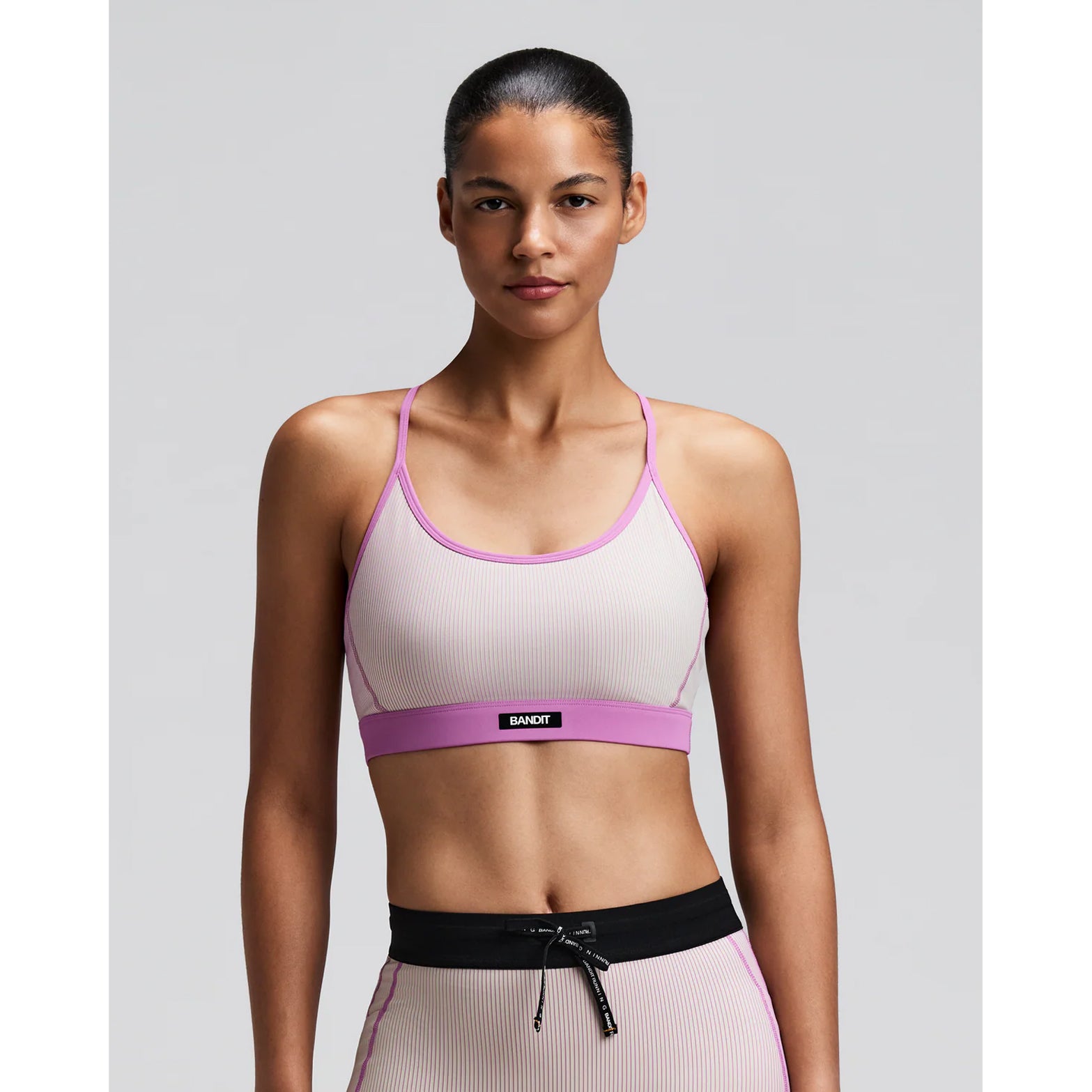 Women's Bandit Striped Cadence Strappy Bra Plaster Orchid front view on female runner showing adjustable straps with Striped Cadence ribbed compression and Vanisher band at hem for race day performance