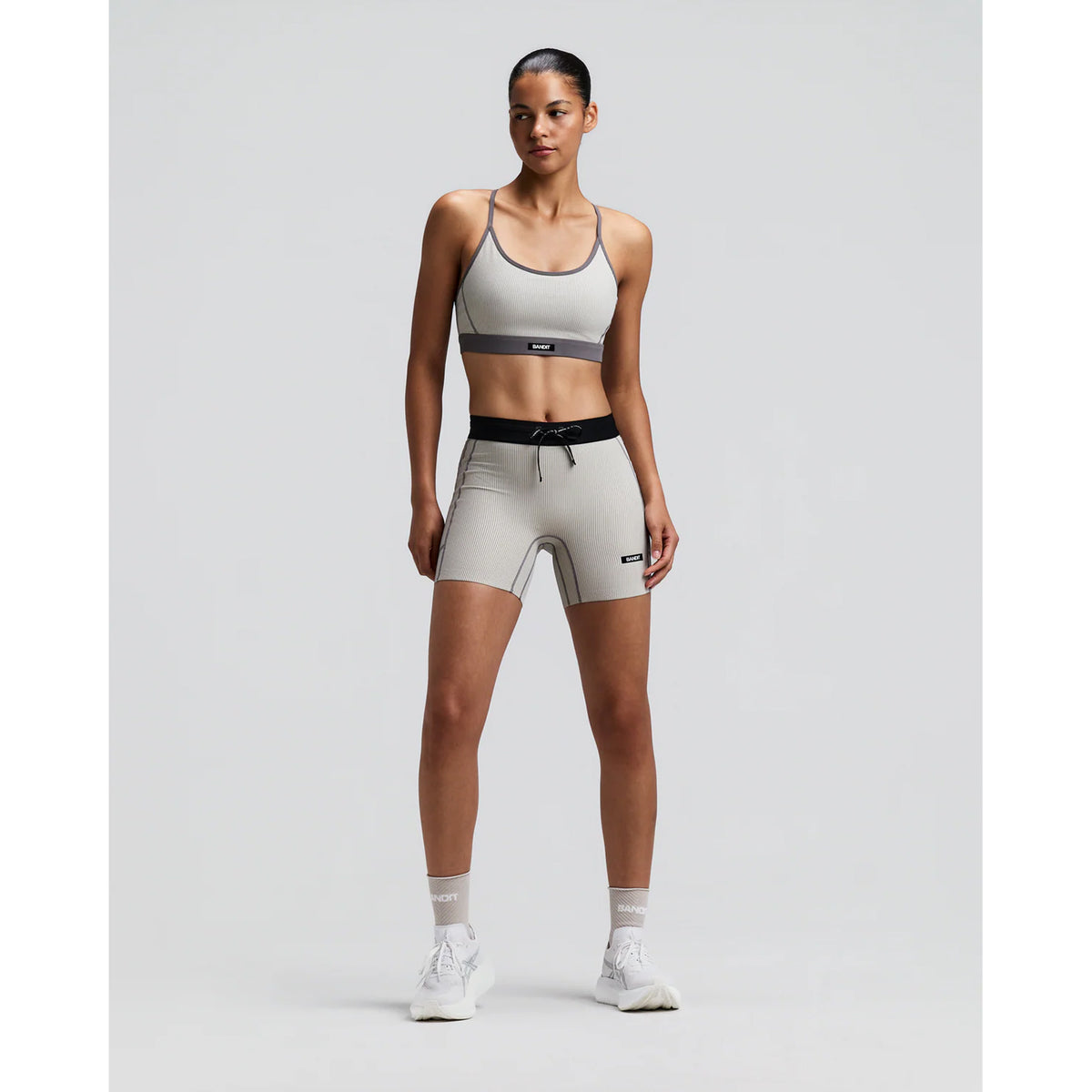 Women's Bandit Striped Cadence Strappy Bra Plaster Slate front full body view on female runner showing adjustable straps with Striped Cadence ribbed compression and three-pocket system for road running and racing