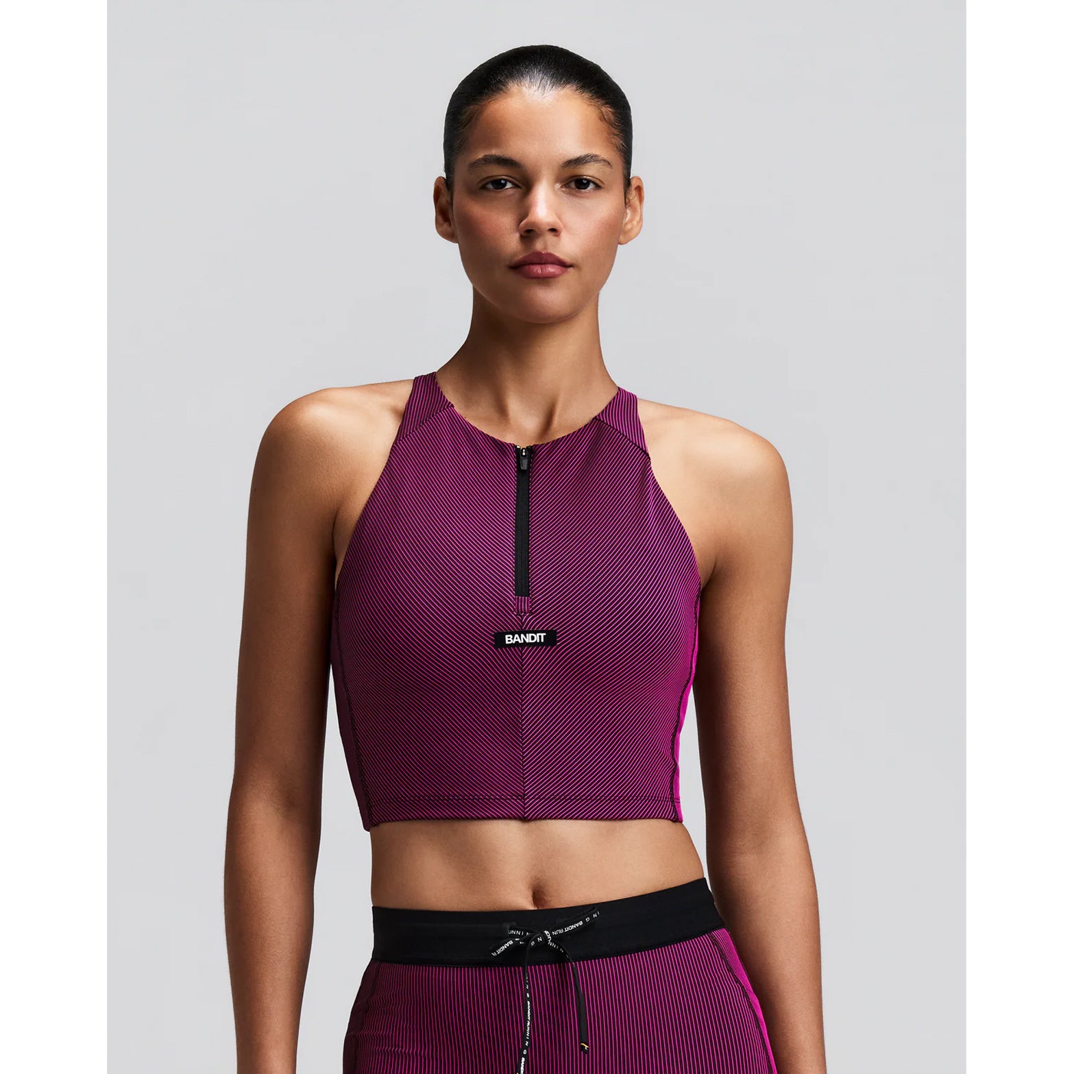 Women's Bandit Striped Cadence Zip Front Race Crop Espresso Azalea front view on female runner showing halter fit with custom-branded zip front and Striped Cadence ribbed compression for race day performance